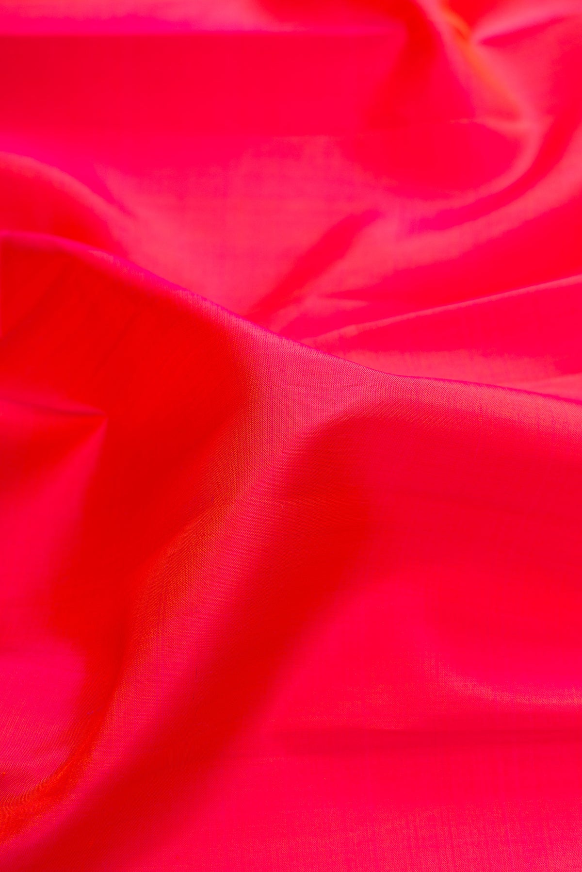 Close up of Pure Silk Brick Orange Dual Tone Kanjivaram Saree with Plain Body and Zari Border.  displaying folds