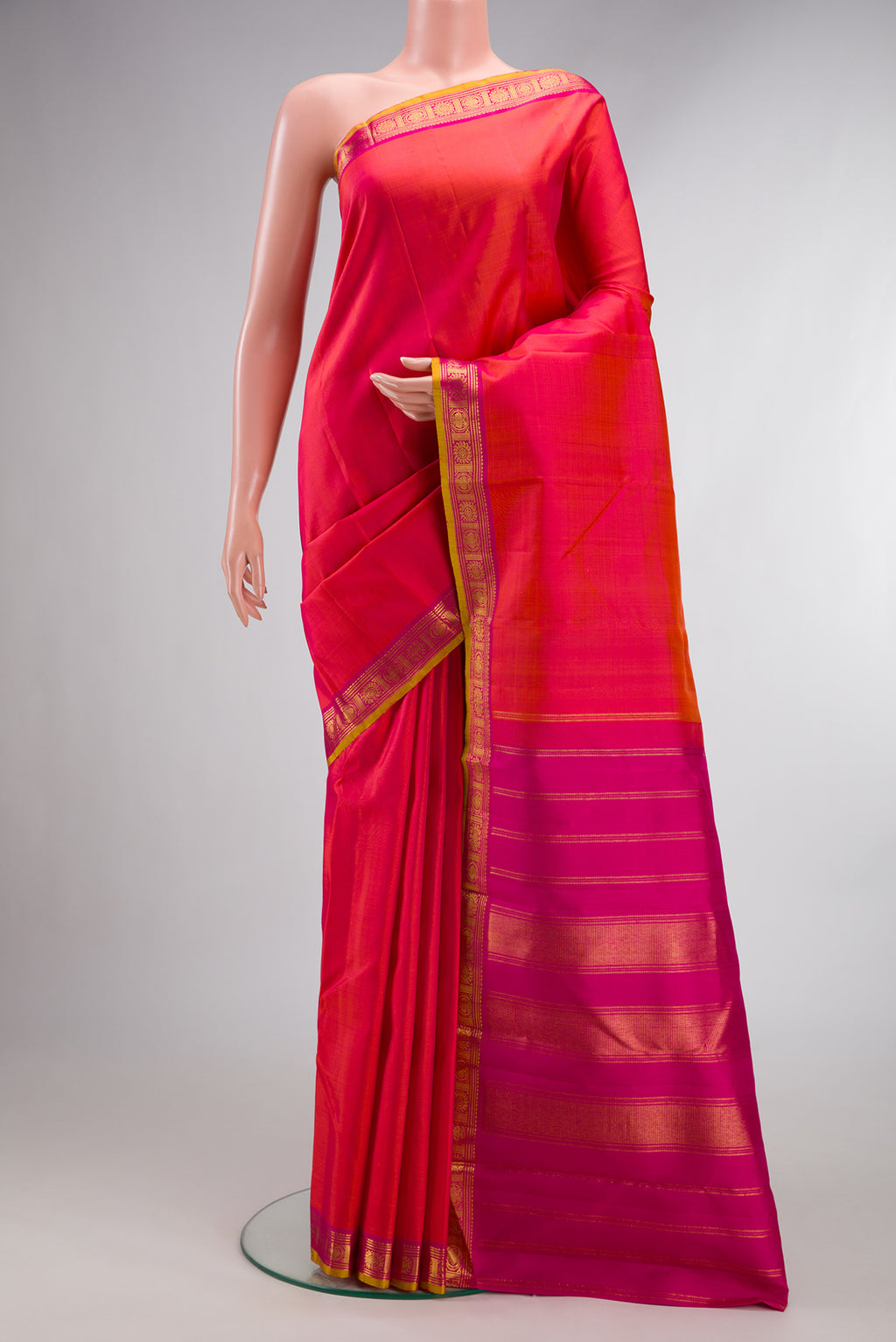 Pure Silk Brick Orange Dual Tone Kanjivaram Saree with Plain Body and Zari Border.  displayed on a mannequin