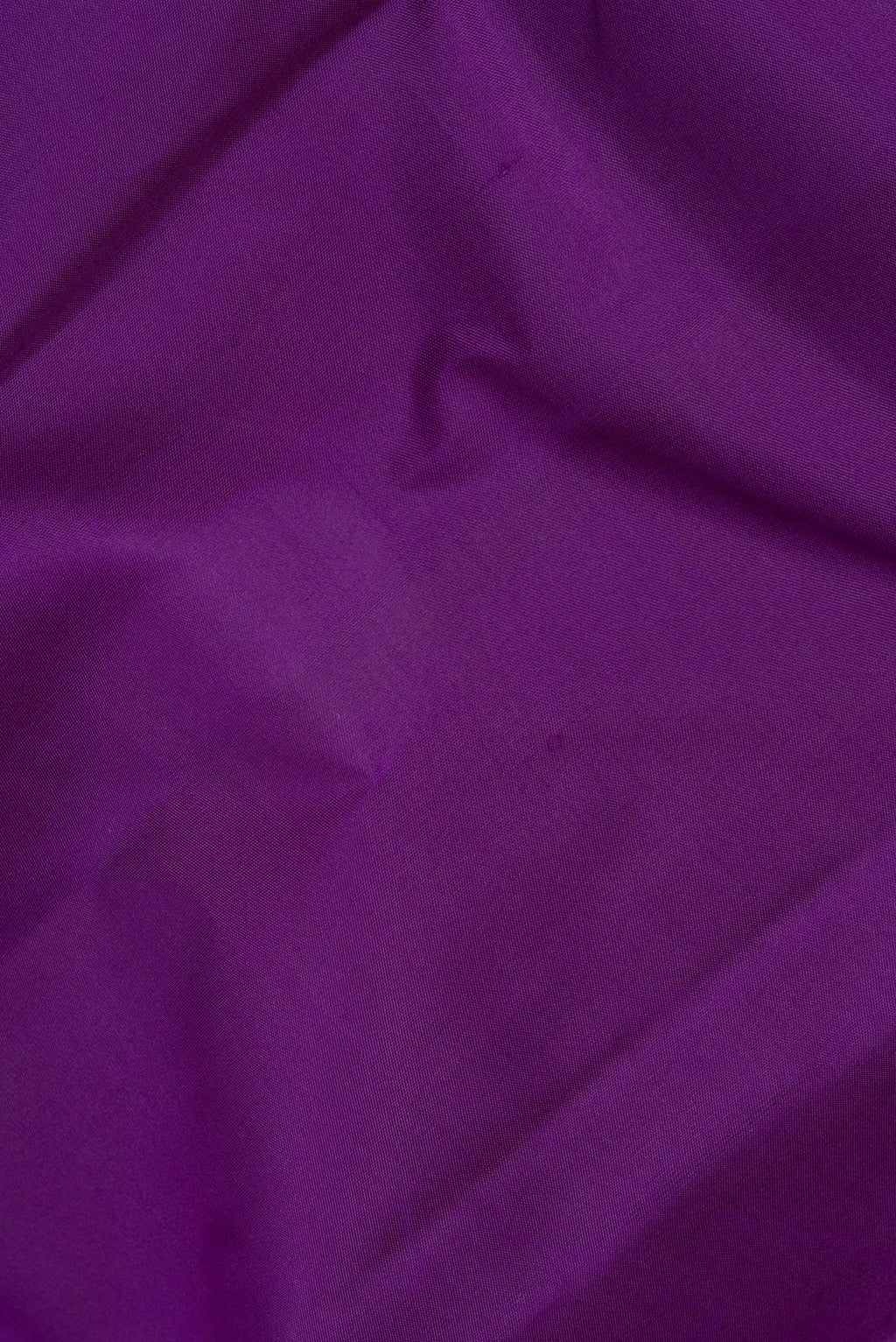 Close up of Pure Silk Purple Kanchipuram Saree with Plain Body and Zari Border.  displaying folds