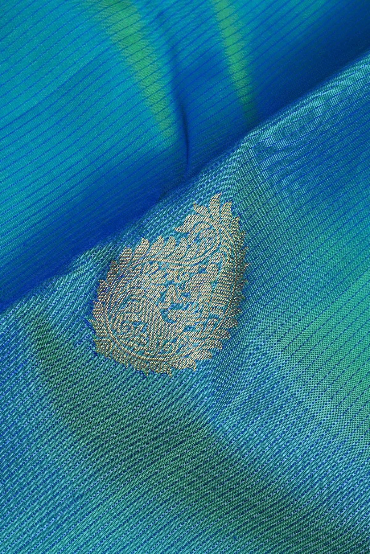 Close up of Pure Silk Peacock Blue Dual Tone Kanchipuram Saree with Zari Butta on the body and Without Border.  displaying folds