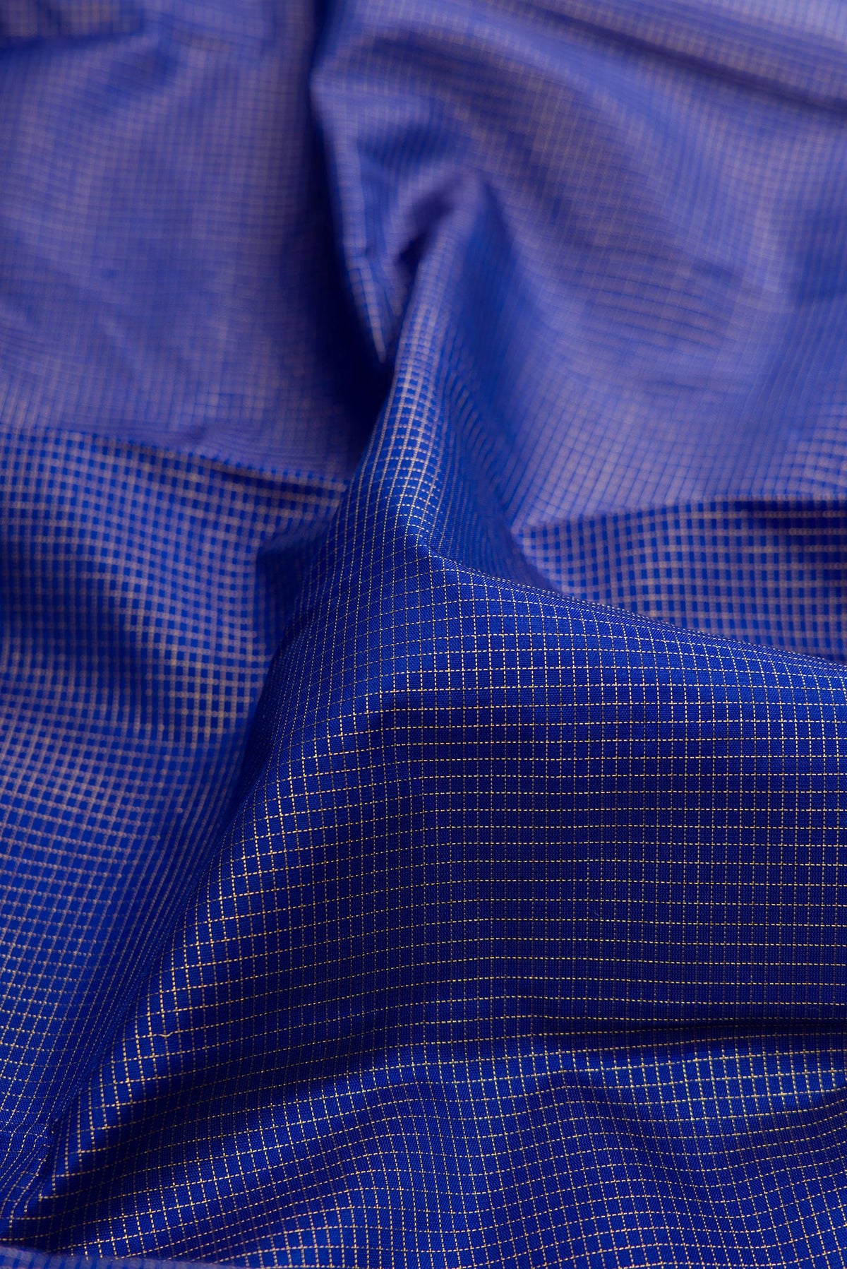 Close up of Pure Silk Royal Blue Kanchipuram Saree with Checked design on the body and Fancy Border.  displaying folds