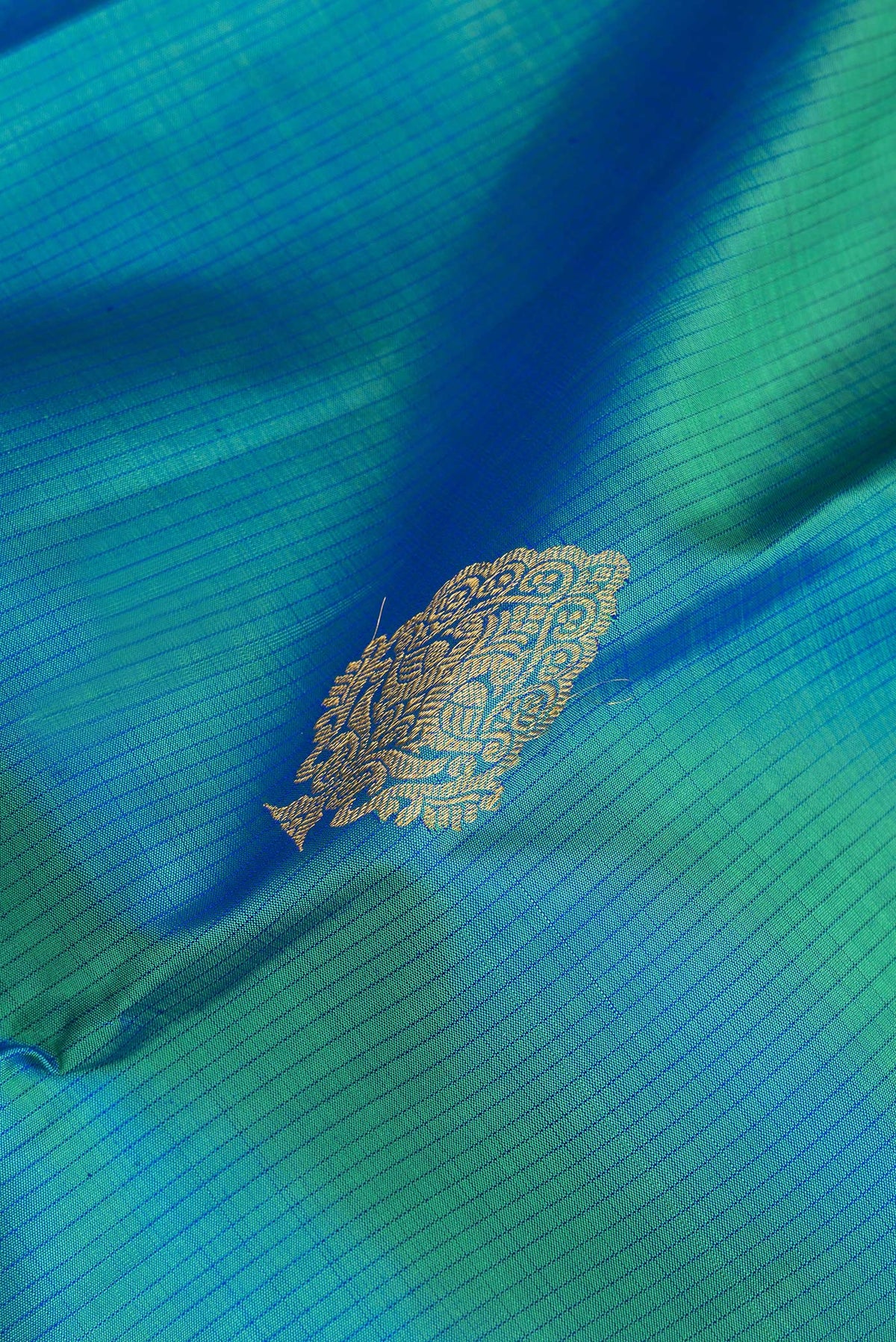 Close up of Pure Silk Peacock Blue Kanjivaram Saree with Stripes on the body and Zari Border.  displaying folds