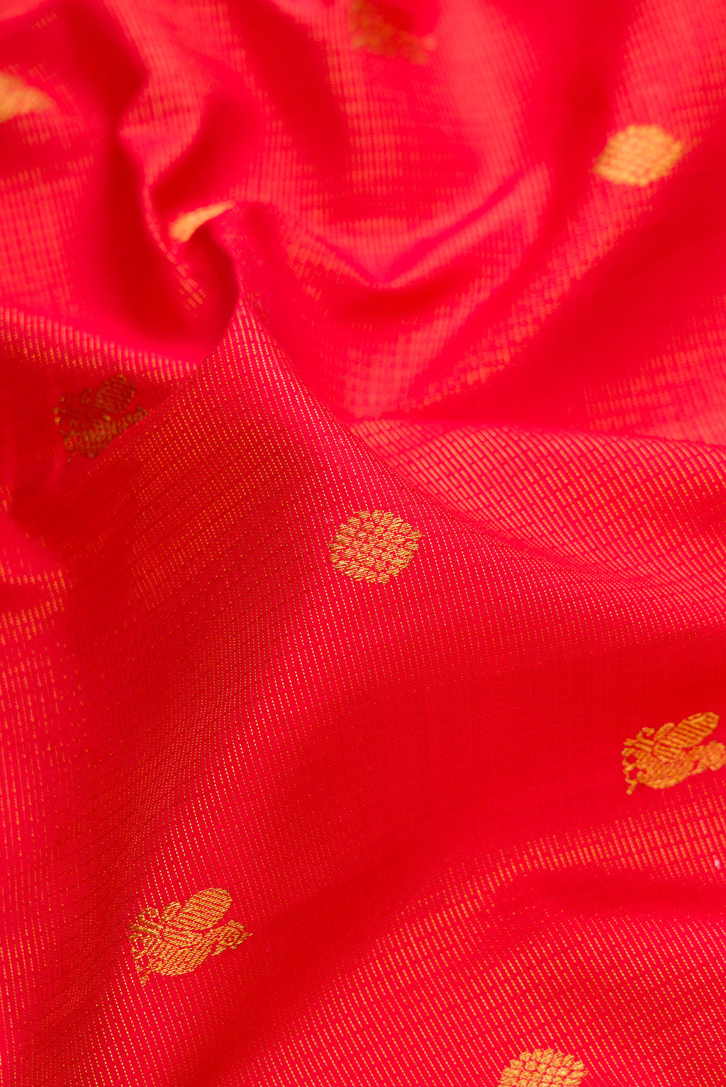 Close up of Pure Silk Brick Orange Dual Tone Kanjivaram Saree with Zari Butta on the body and Zari Border.  displaying folds
