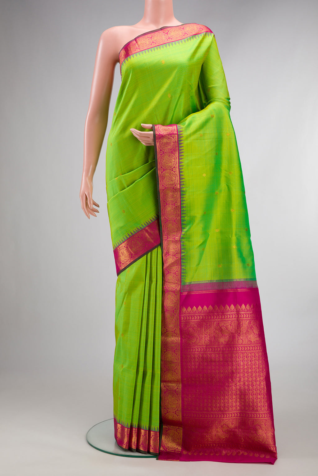 Pure Silk Parrot Green Kanjivaram Saree with Zari Butta on the body and Temple Border.  displayed on a mannequin