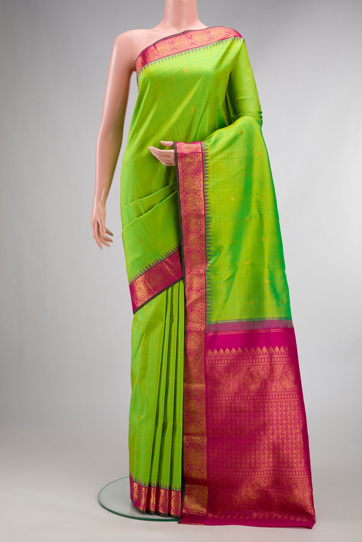 Pure Silk Parrot Green Kanjivaram Saree with Zari Butta on the body and Temple Border.  displayed on a mannequin