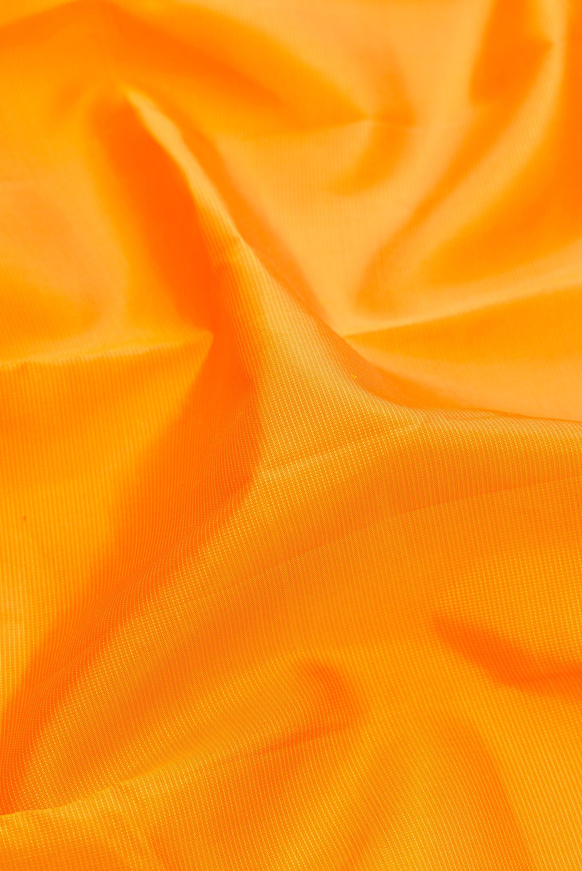 Close up of Pure Silk Yellow Kanjivaram Saree with Stripes on the body and Temple Border.  displaying folds