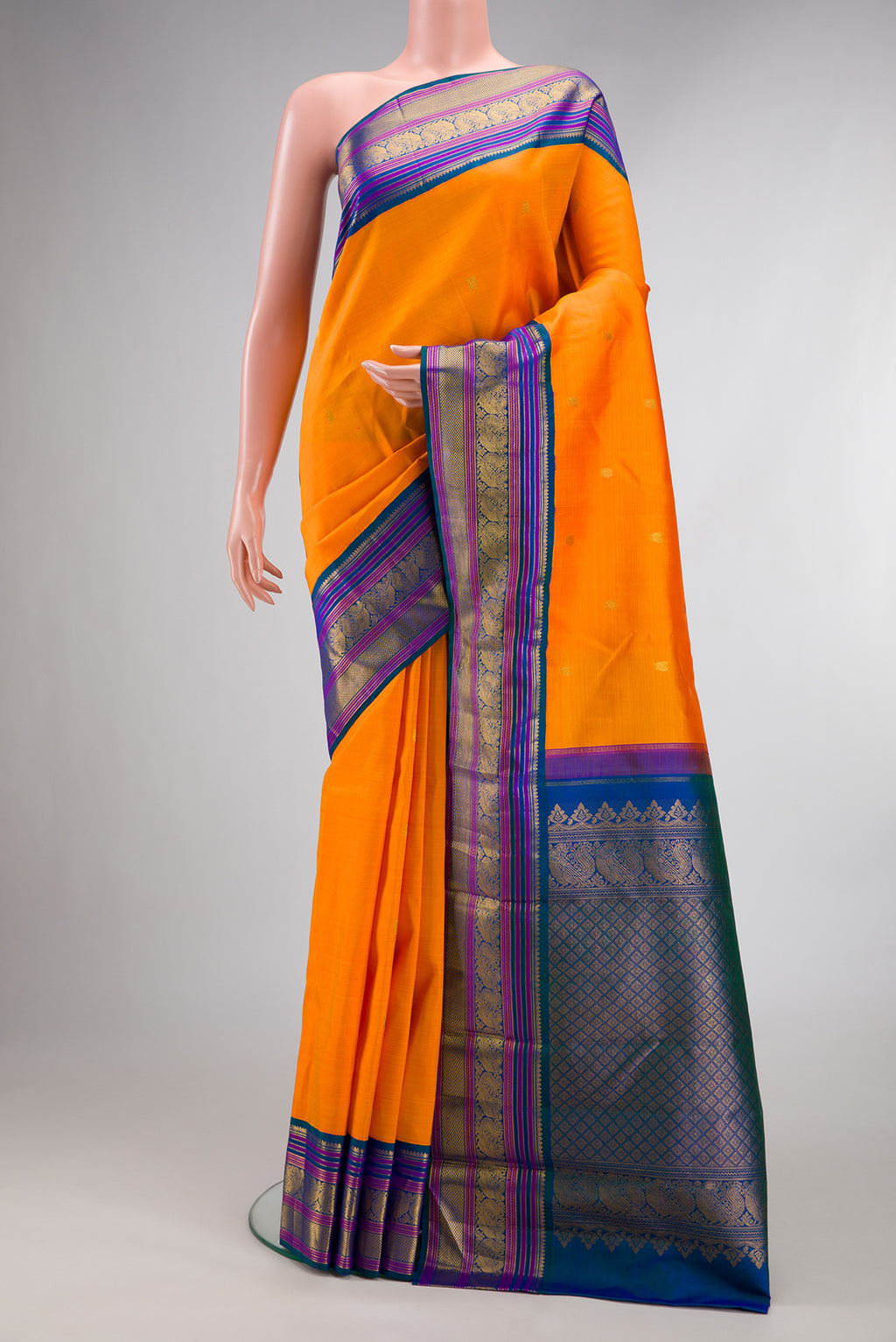 Pure Silk Orange Dual Tone Kanjivaram Saree with Zari Butta on the body and Zari Border.  displayed on a mannequin