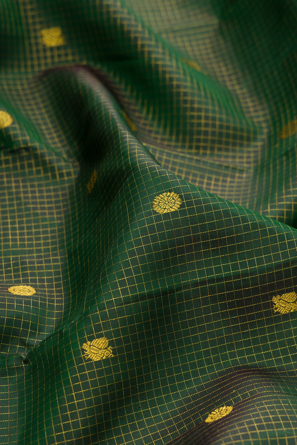 Close up of Pure Silk Green Kanjivaram Saree with Checked design on the body and Zari Border.  displaying folds