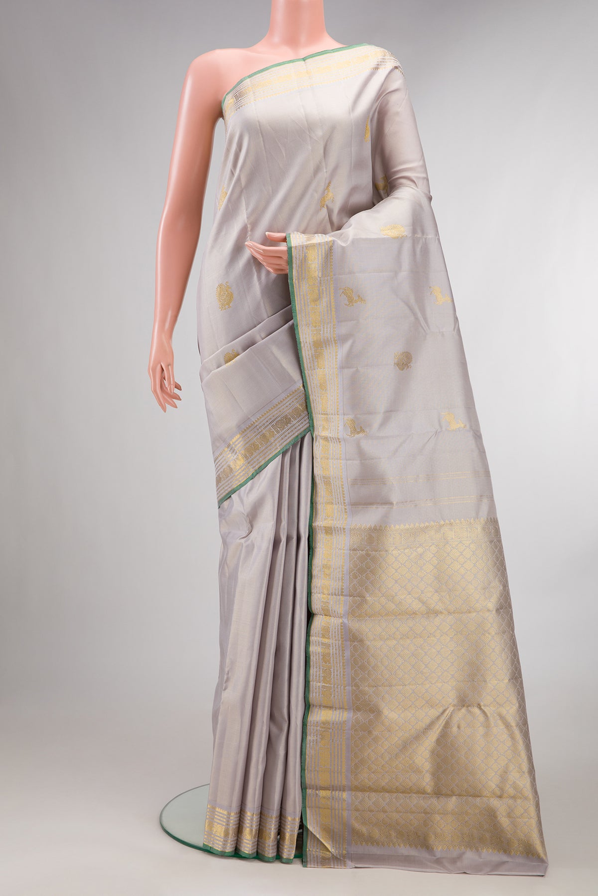 Pure Silk Cream Kanjivaram Saree with Zari Butta on the body and Zari Border.  displayed on a mannequin