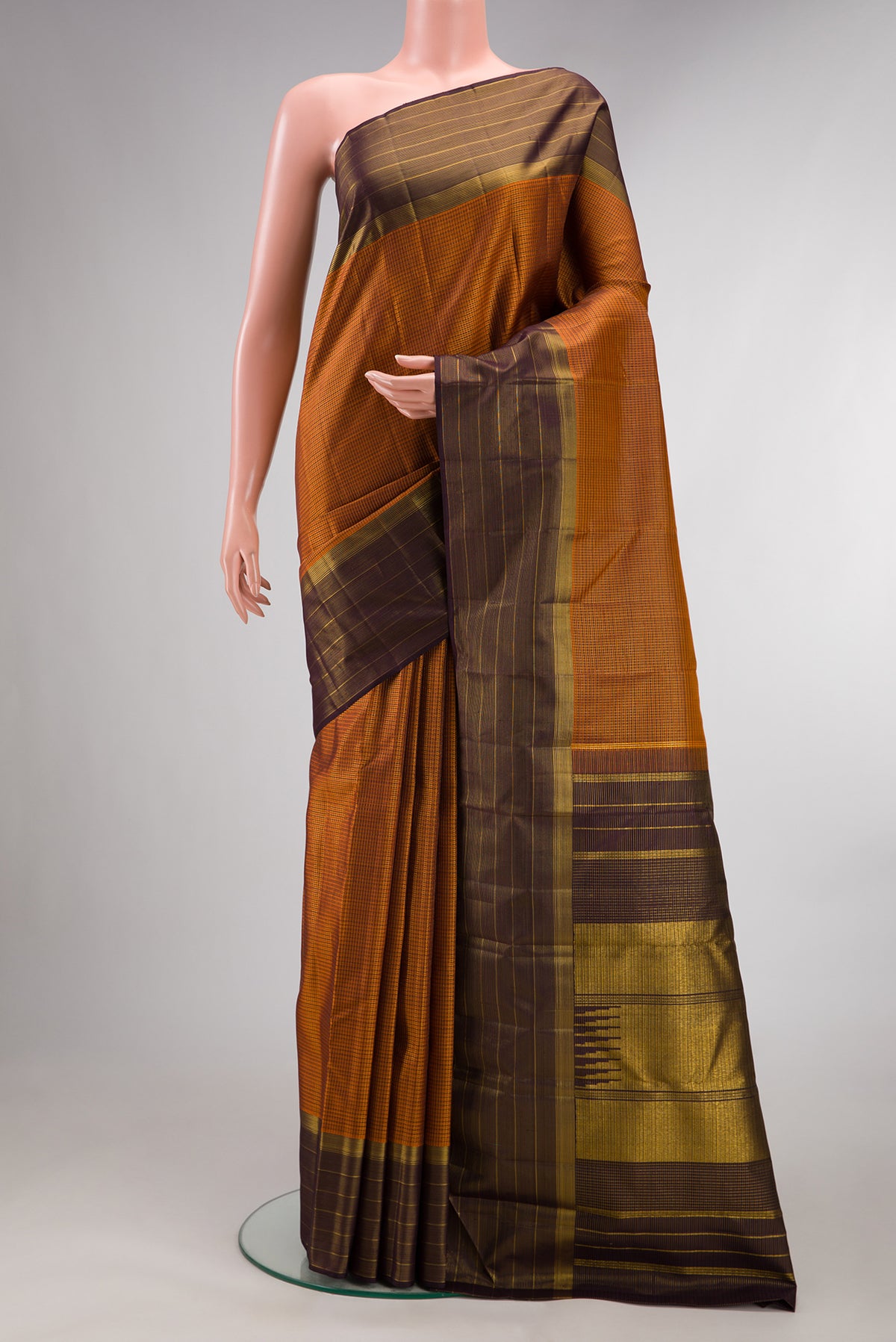 Pure Silk Brick Orange Kanchipuram Saree with Checked design on the body and Zari Border.  displayed on a mannequin