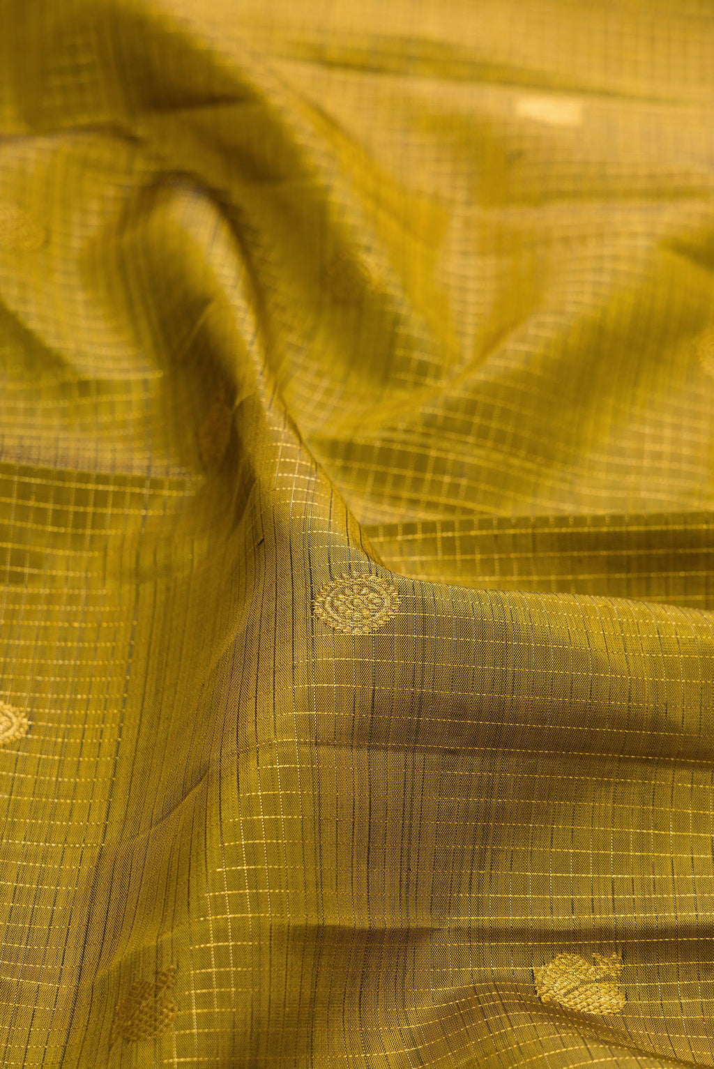 Close up of Pure Silk Mehandi Green Kanjivaram Saree with Zari Butta on the body and Plain Border.  displaying folds
