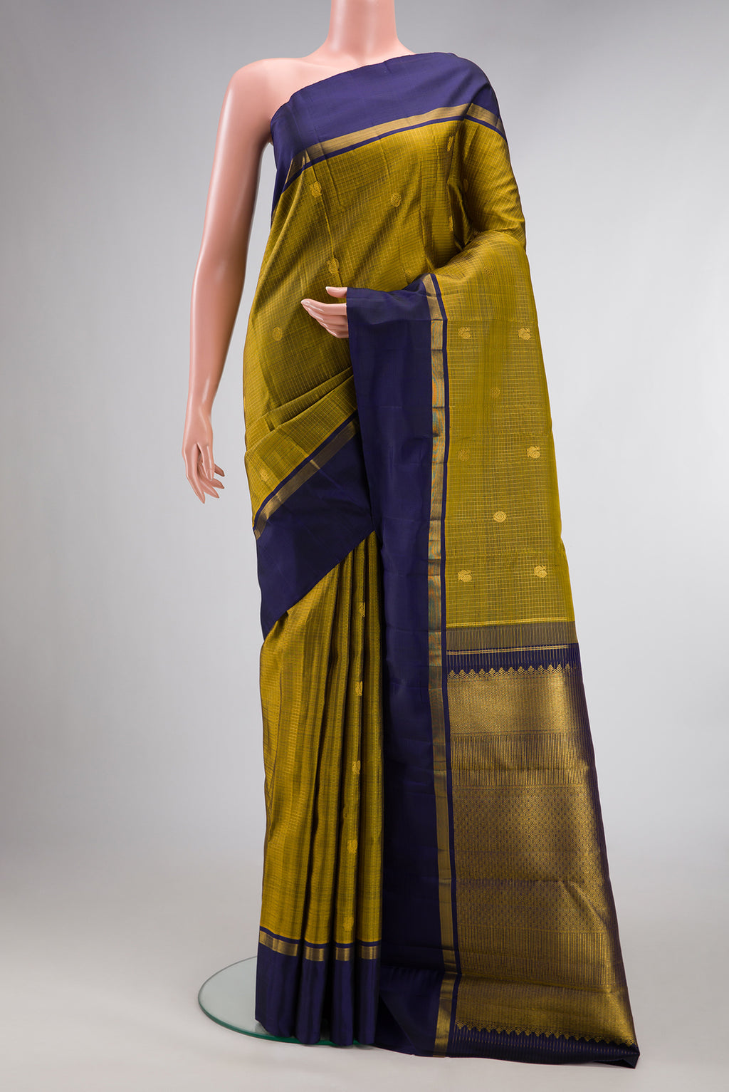 Pure Silk Mehandi Green Kanjivaram Saree with Zari Butta on the body and Plain Border.  displayed on a mannequin