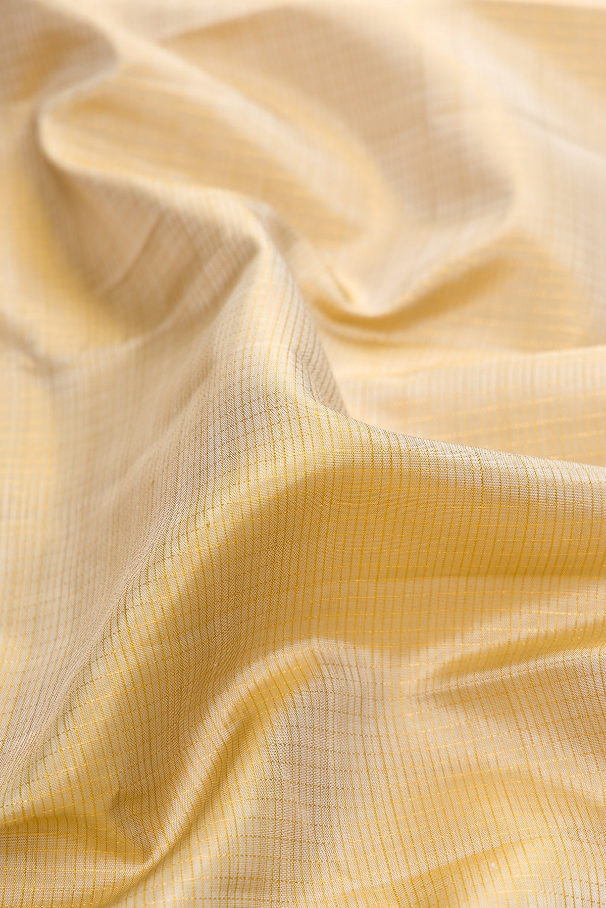 Close up of Pure Silk Beige Kanjivaram Saree with Checked design on the body and Zari Border.  displaying folds