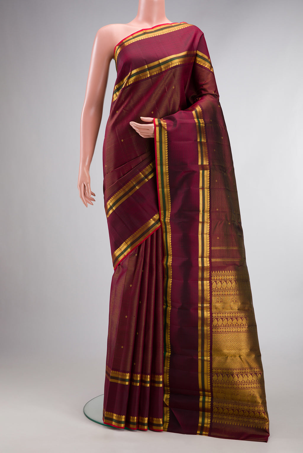 Pure Silk Maroon Kanjivaram Saree with Stripes on the body and Zari Border.  displayed on a mannequin
