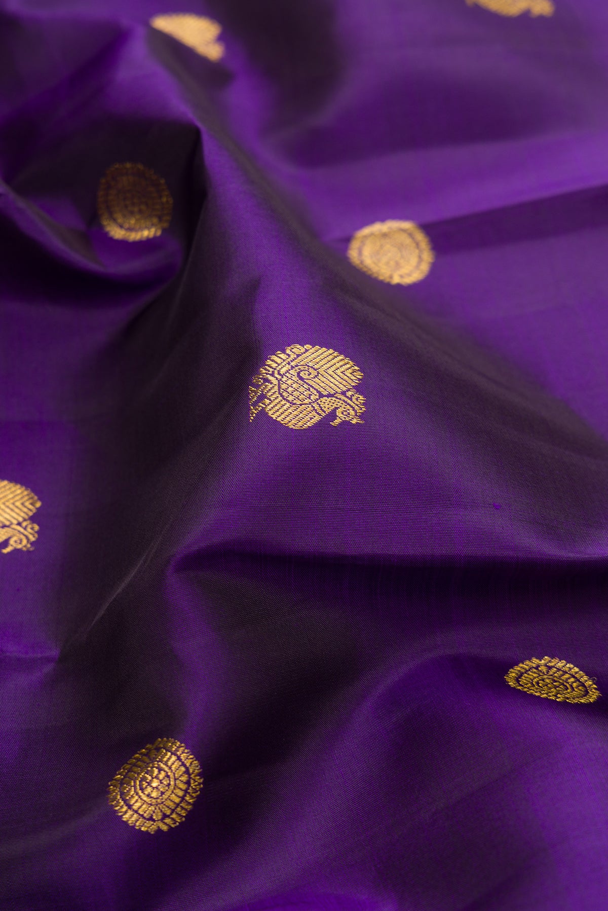 Close up of Pure Silk Violet Kanjivaram Saree with Zari Butta on the body and Zari Border.  displaying folds