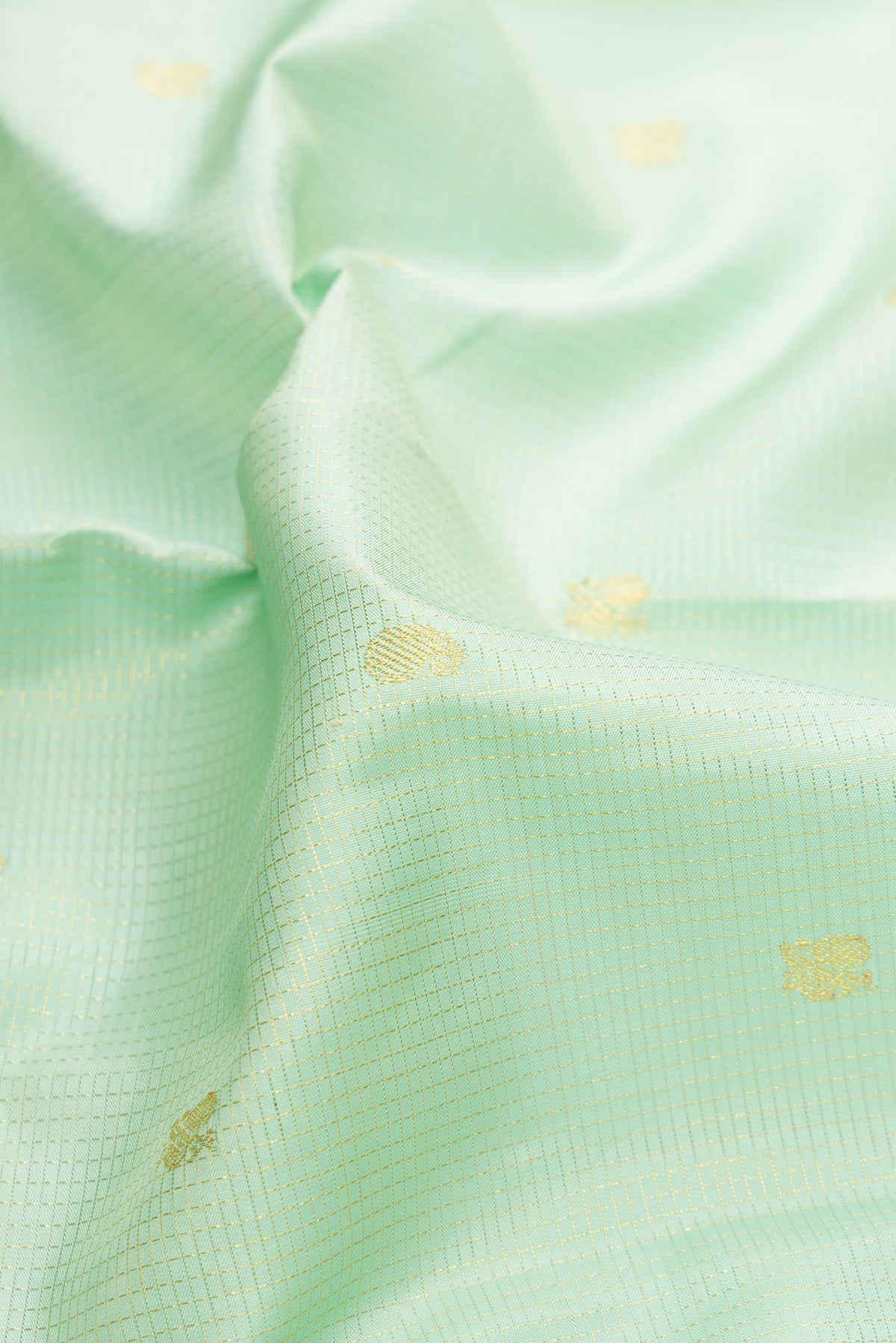 Close up of Pure Silk Pista Green Kanchipuram Saree with Checked design on the body and Zari Border.  displaying folds