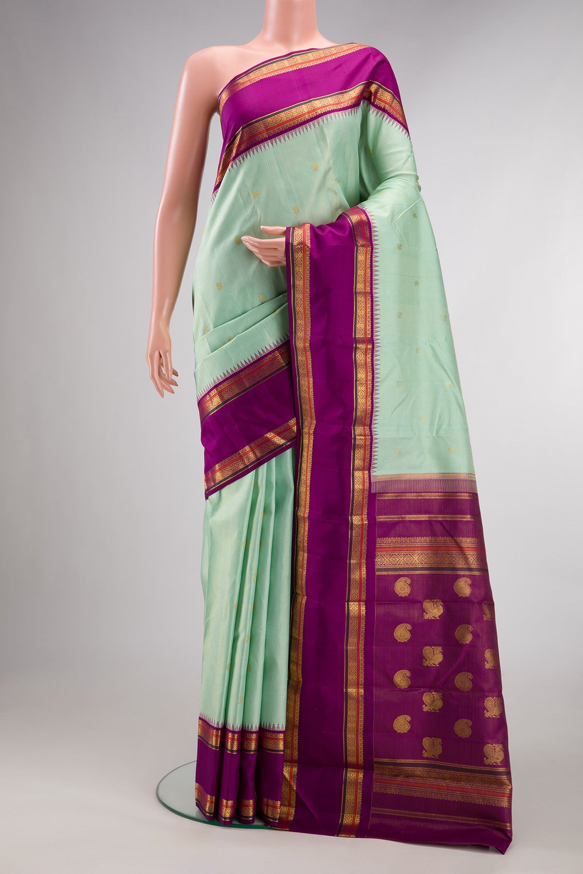 Pure Silk Pista Green Kanchipuram Saree with Checked design on the body and Zari Border.  displayed on a mannequin