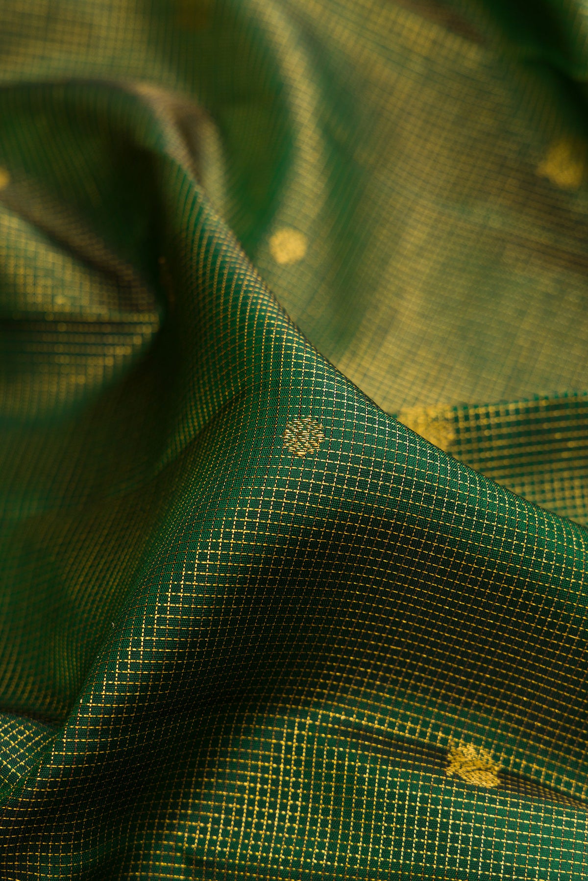 Close up of Pure Silk Bottle Green Kanchipuram Saree with Checked design on the body and Zari Border.  displaying folds