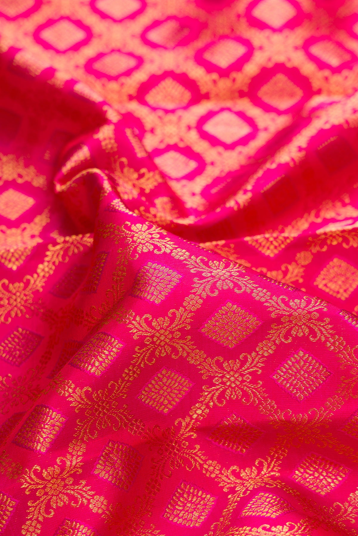 Close up of Pure Silk Dark Pink Kanchipuram Saree with Zari Brocade on the body and Zari Border.  displaying folds