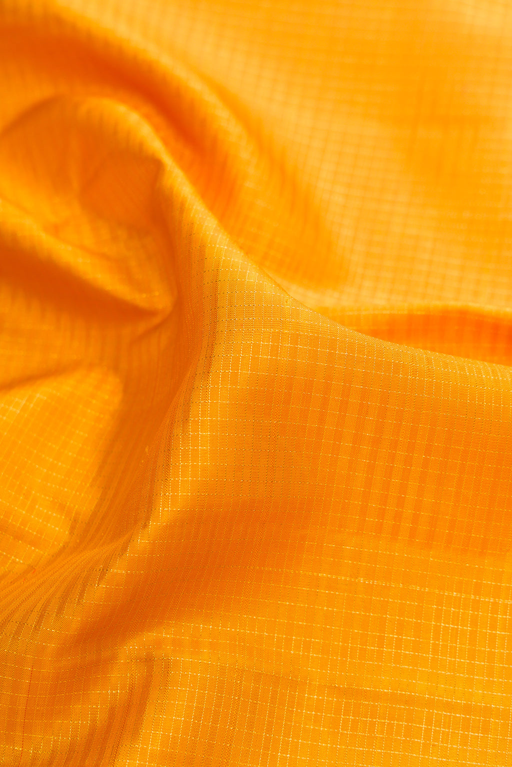 Close up of Pure Silk Mustard Kanjivaram Saree with Checked design on the body and Zari Border.  displaying folds