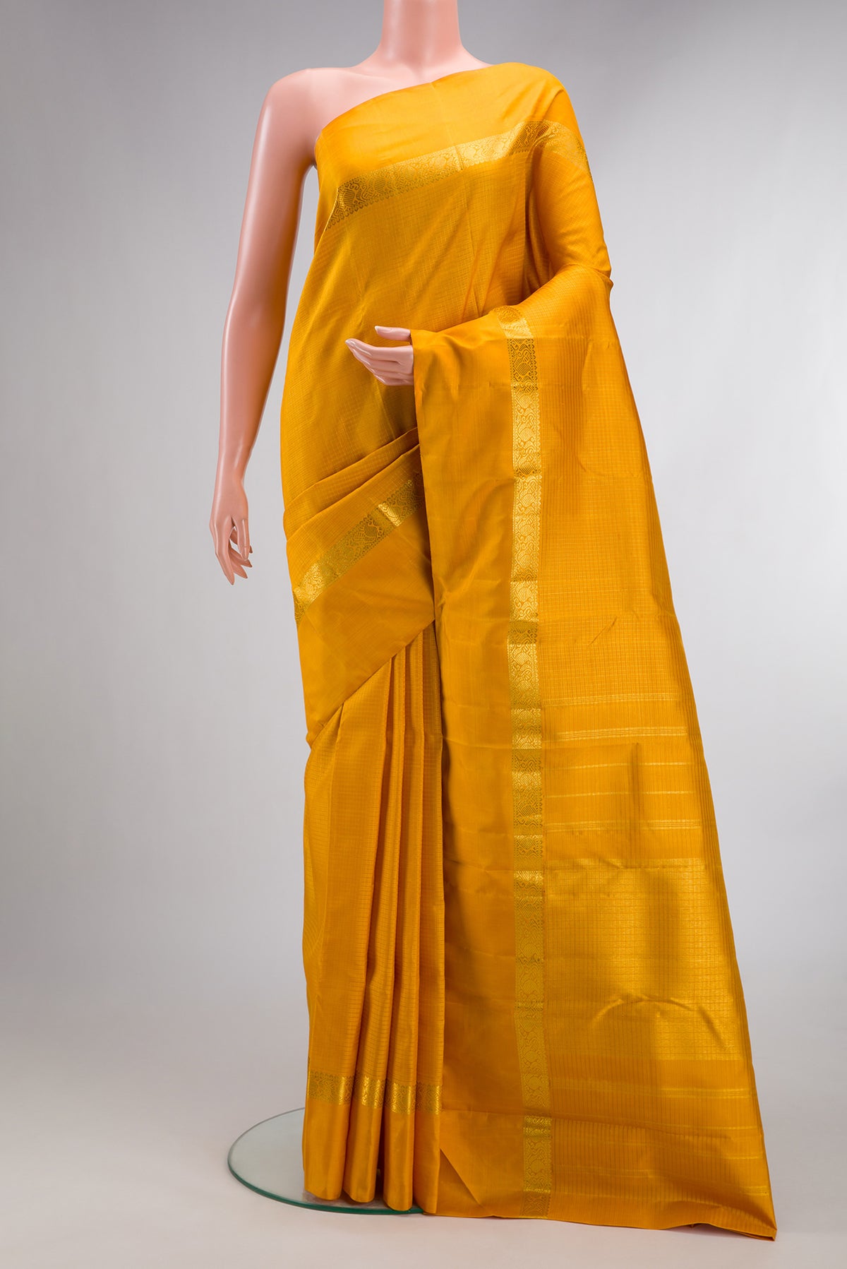Pure Silk Mustard Kanjivaram Saree with Checked design on the body and Zari Border.  displayed on a mannequin
