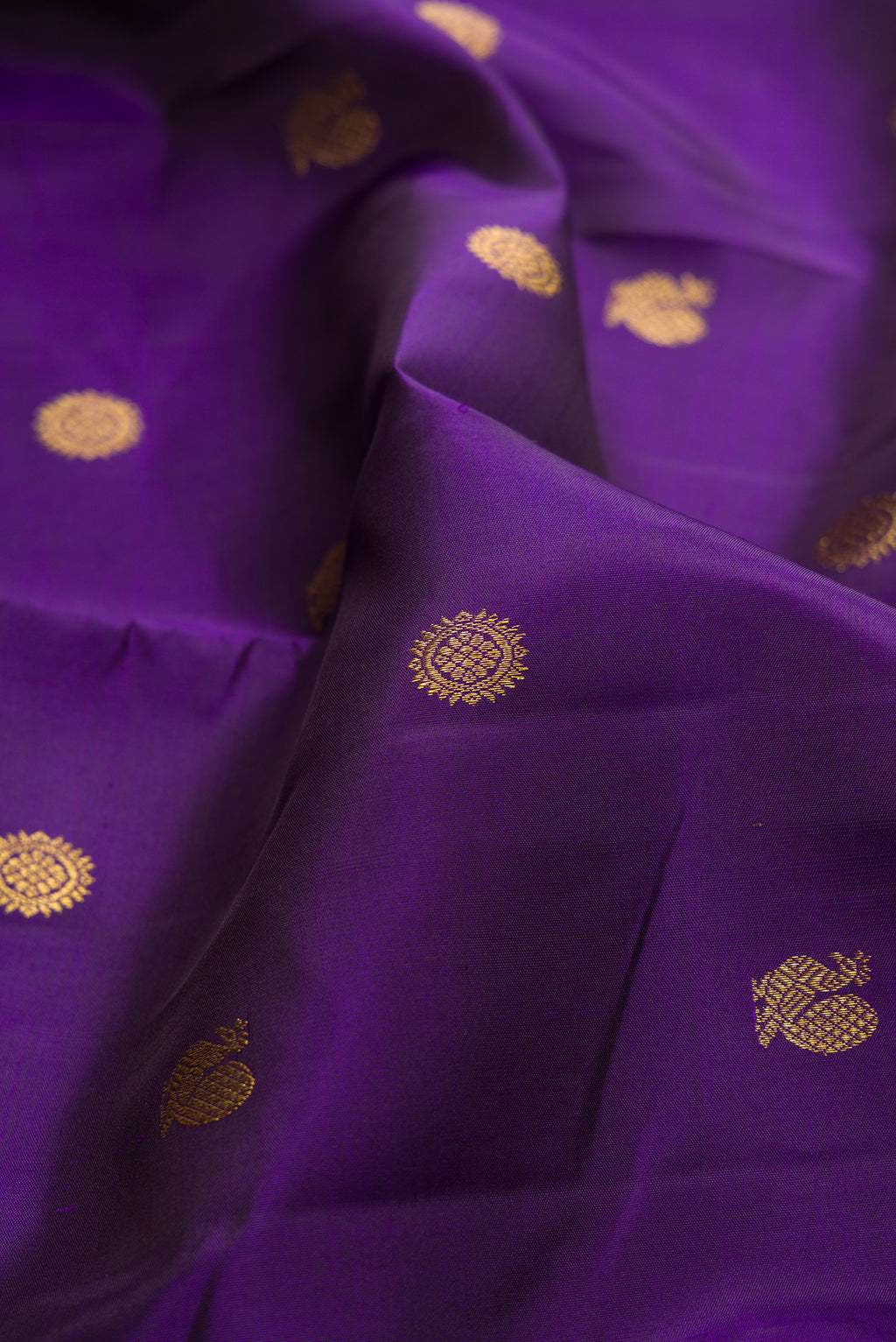 Close up of Pure Silk Violet Kanchipuram Saree with Zari Butta on the body and Zari Border.  displaying folds