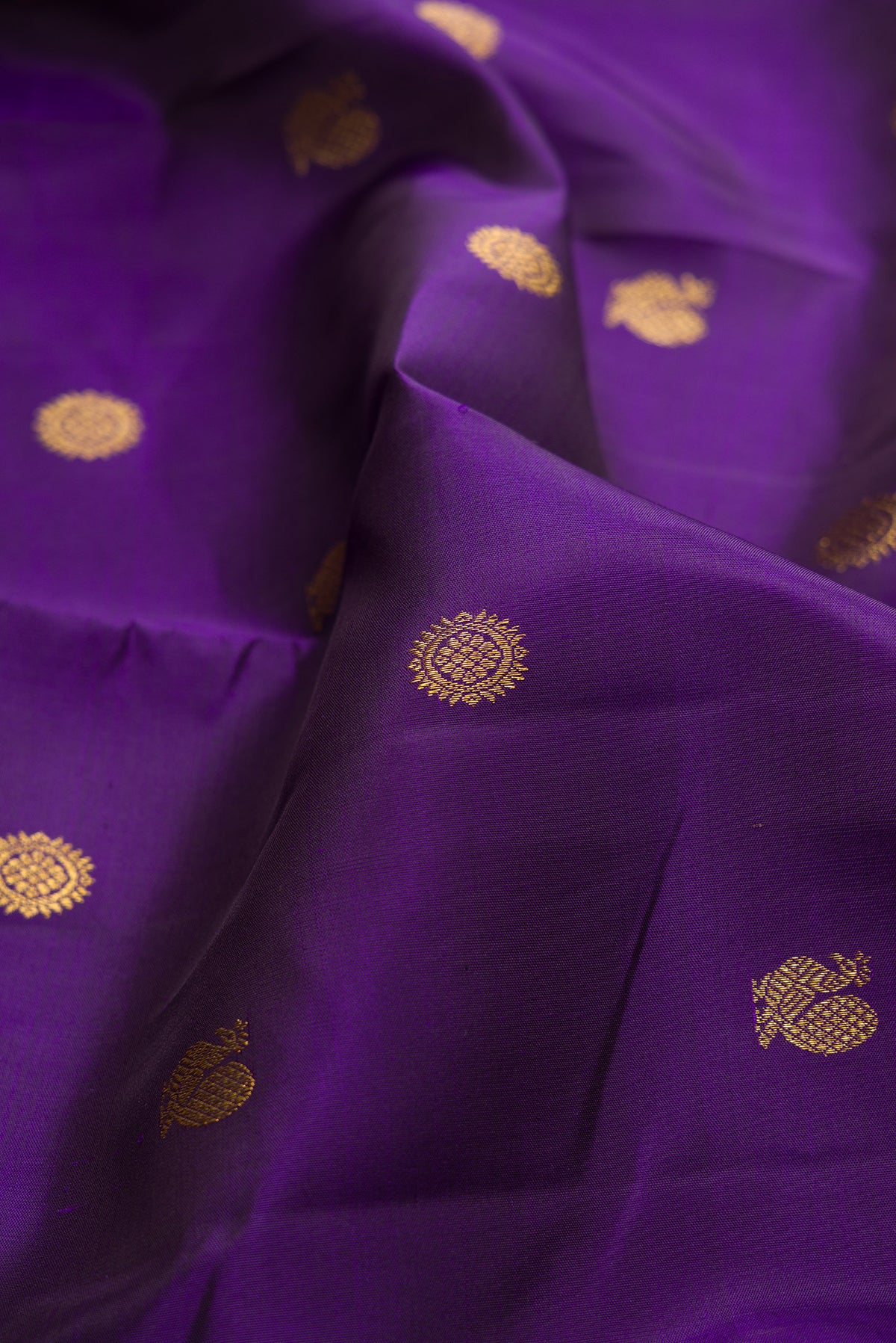 Close up of Pure Silk Violet Kanchipuram Saree with Zari Butta on the body and Zari Border.  displaying folds