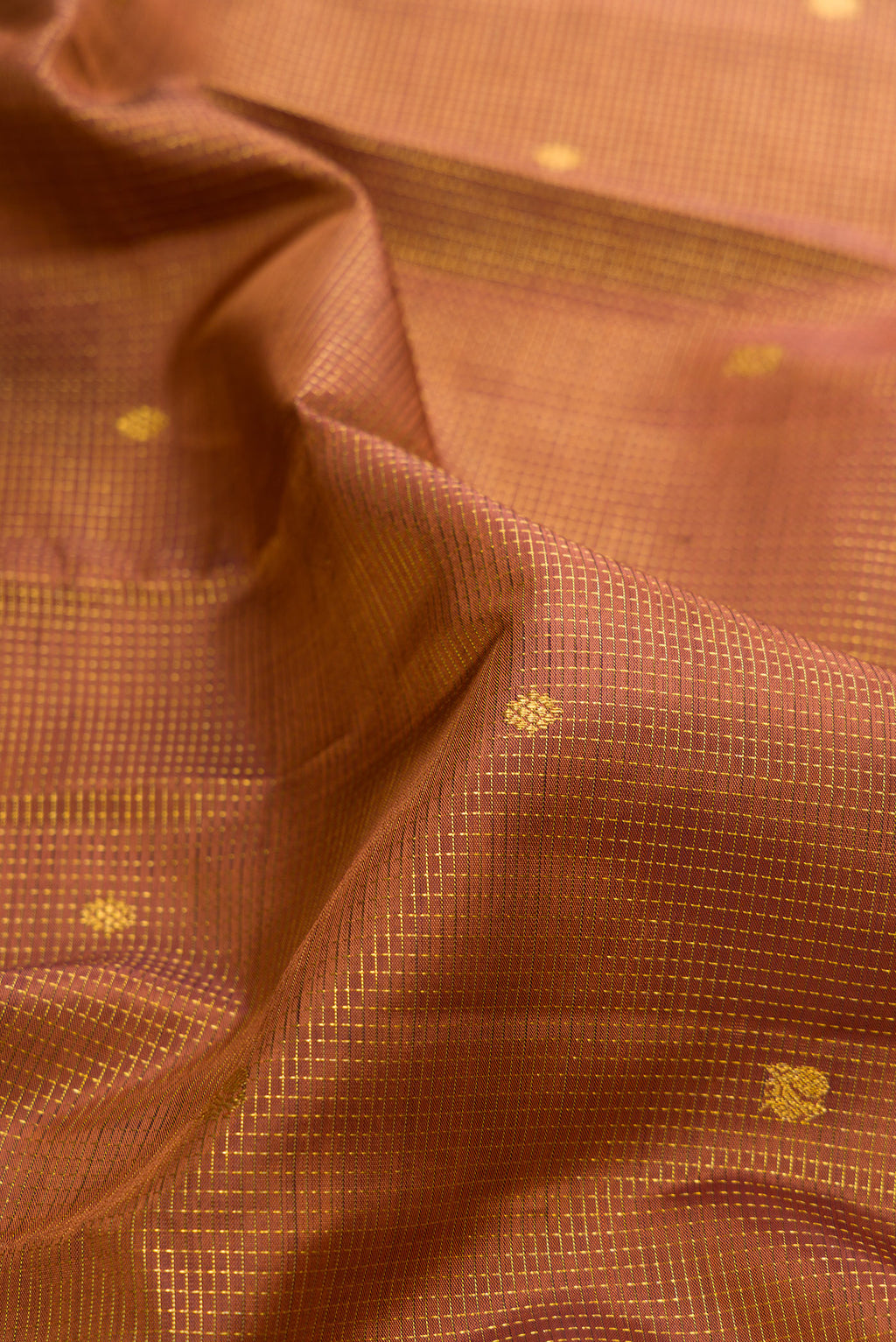 Close up of Pure Silk Brown Kanchipuram Saree with Zari Butta on the body and Zari Border.  displaying folds