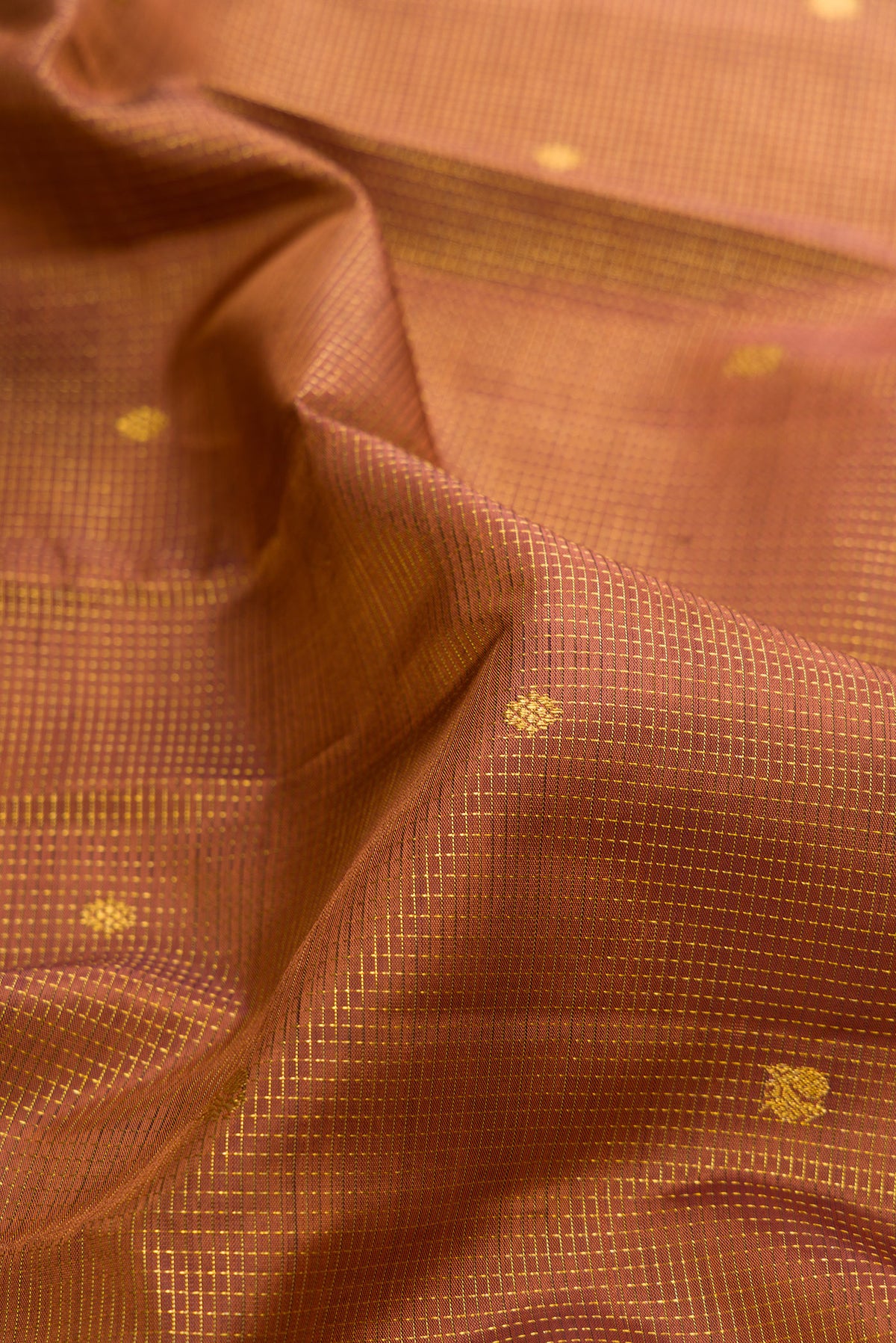 Close up of Pure Silk Brown Kanchipuram Saree with Zari Butta on the body and Zari Border.  displaying folds