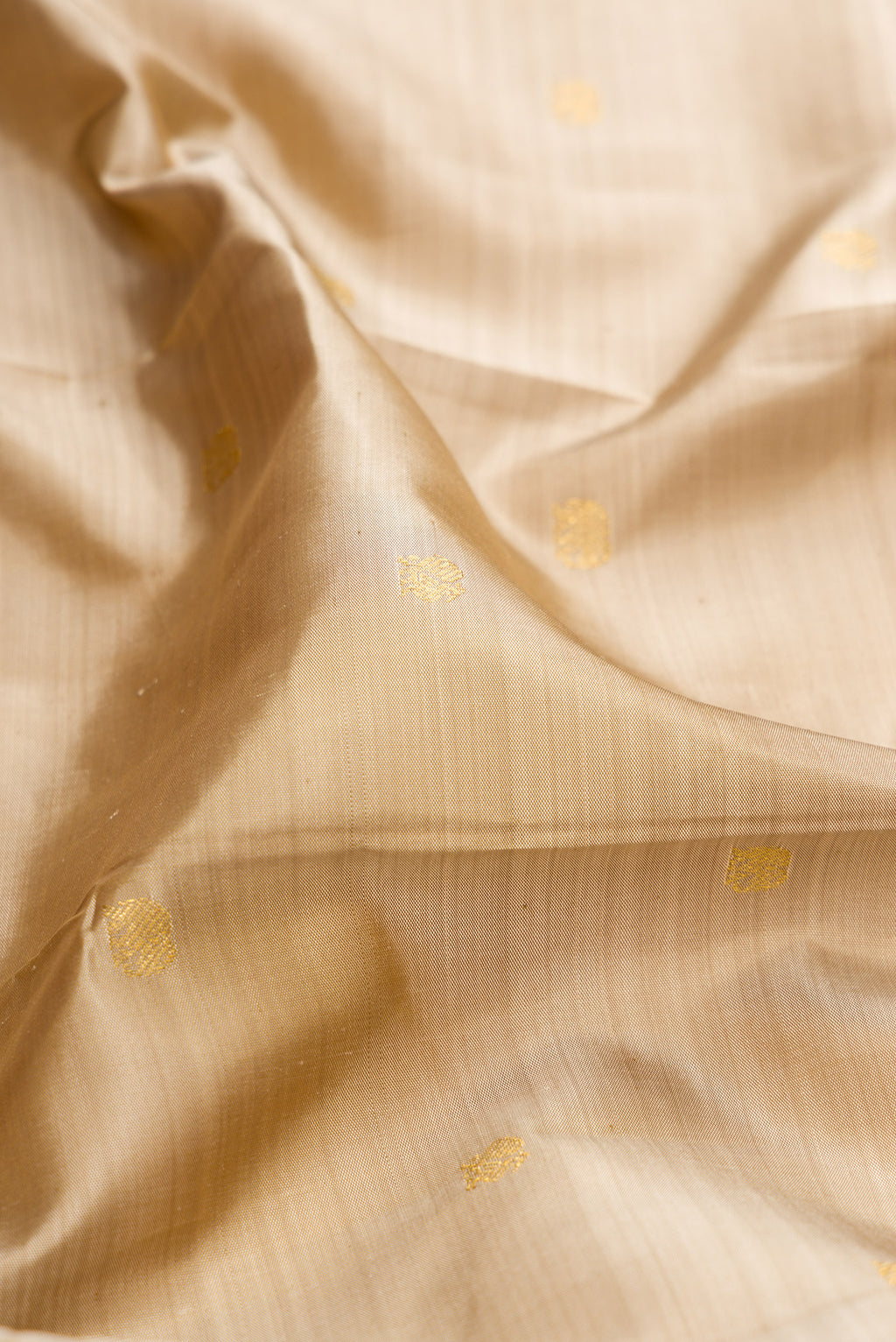 Close up of Pure Silk Dark Beige Kanchipuram Saree with Zari Butta on the body and Zari And Thread Border.  displaying folds