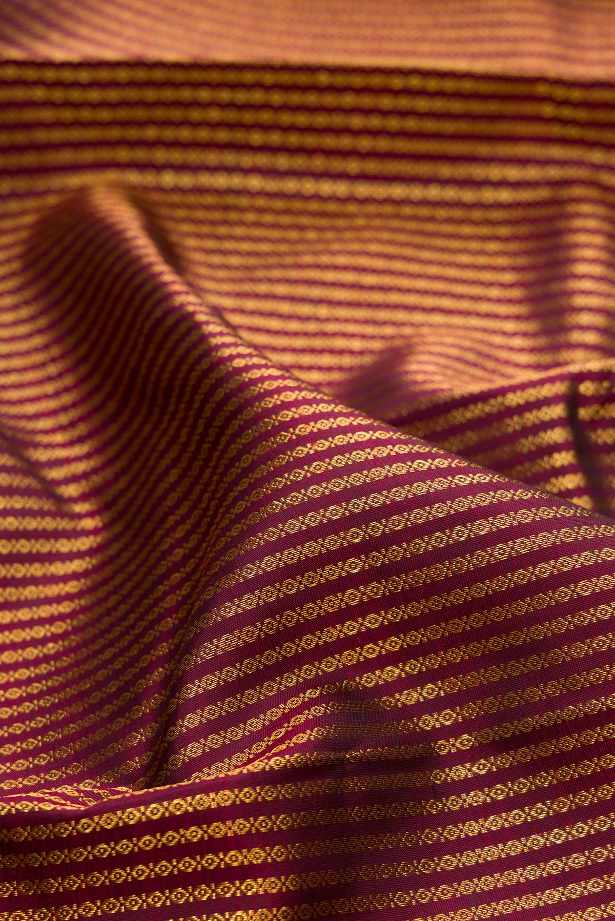 Close up of Pure Silk Coffee Brown Kanchipuram Saree with Zari Brocade on the body and Zari Border.  displaying folds
