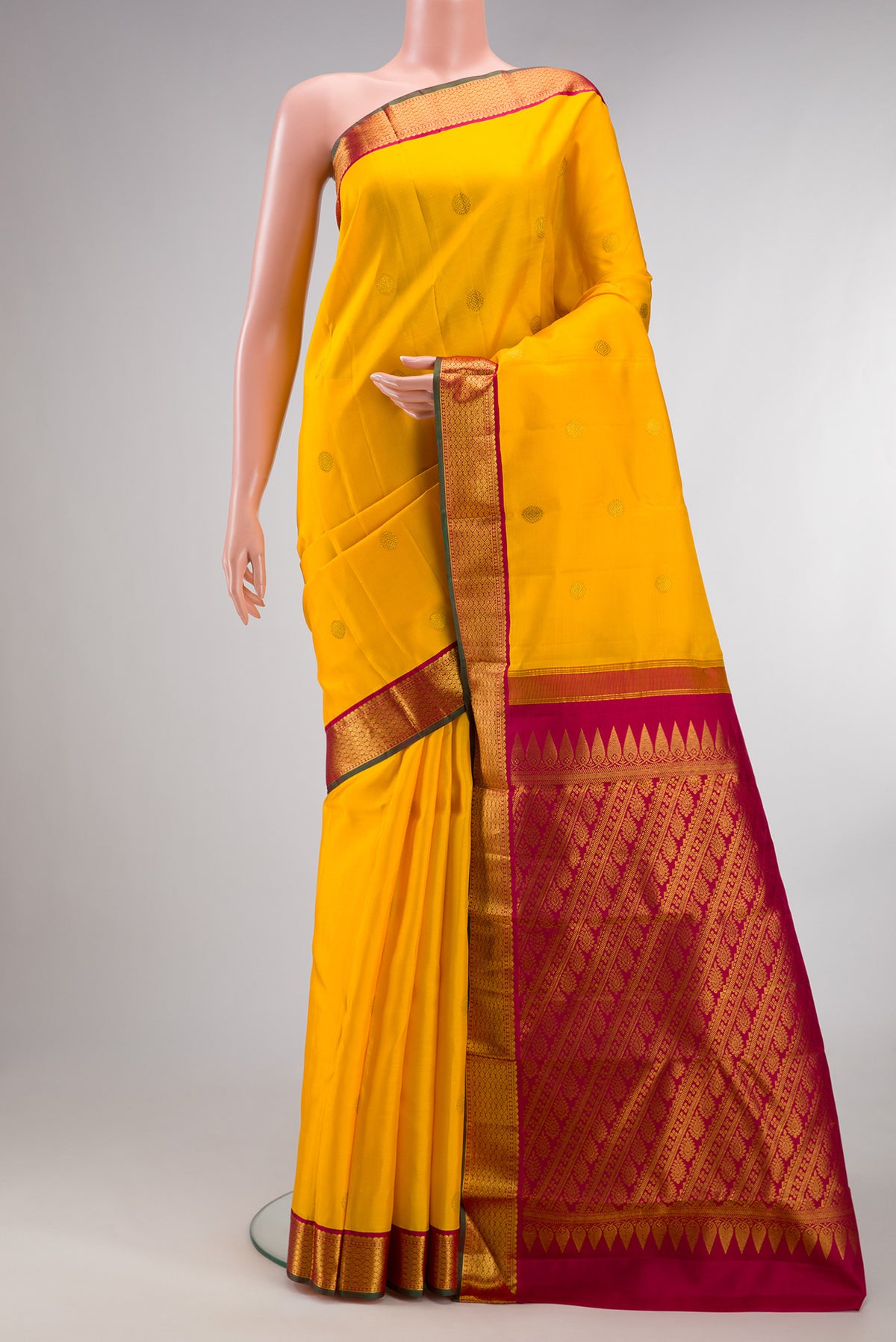 Pure Silk Yellow Kanjivaram Saree with Zari Butta on the body and Zari Border.  displayed on a mannequin