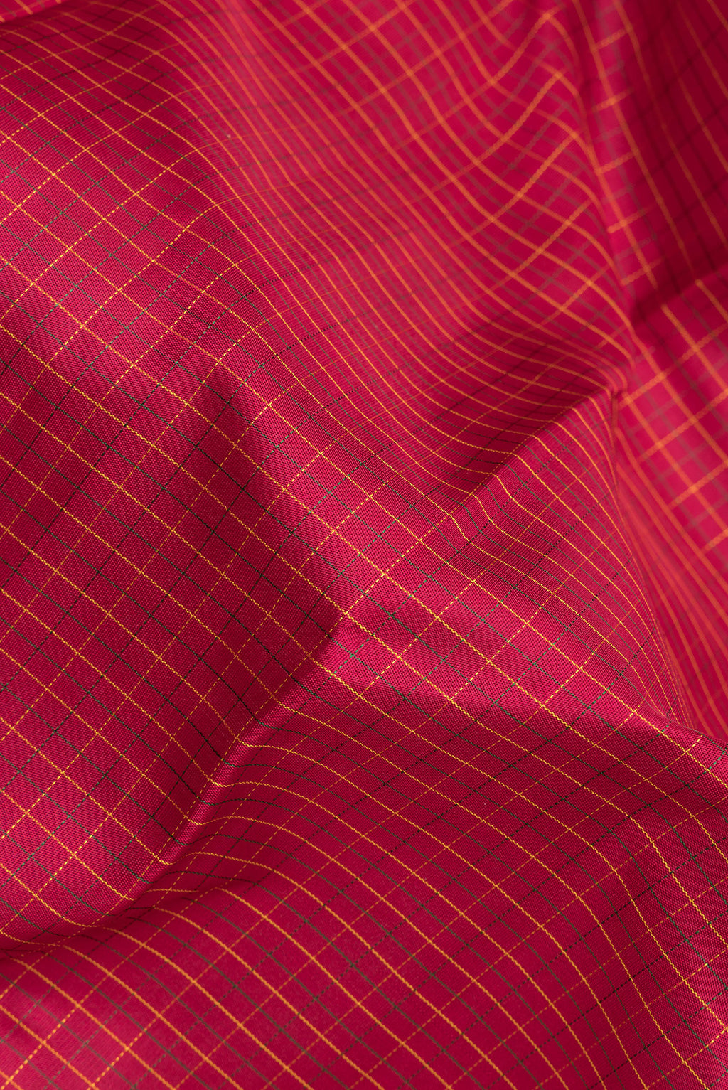 Close up of Pure Silk Deep Red Kanchipuram Saree with Checked design on the body and Zari Border.  displaying folds