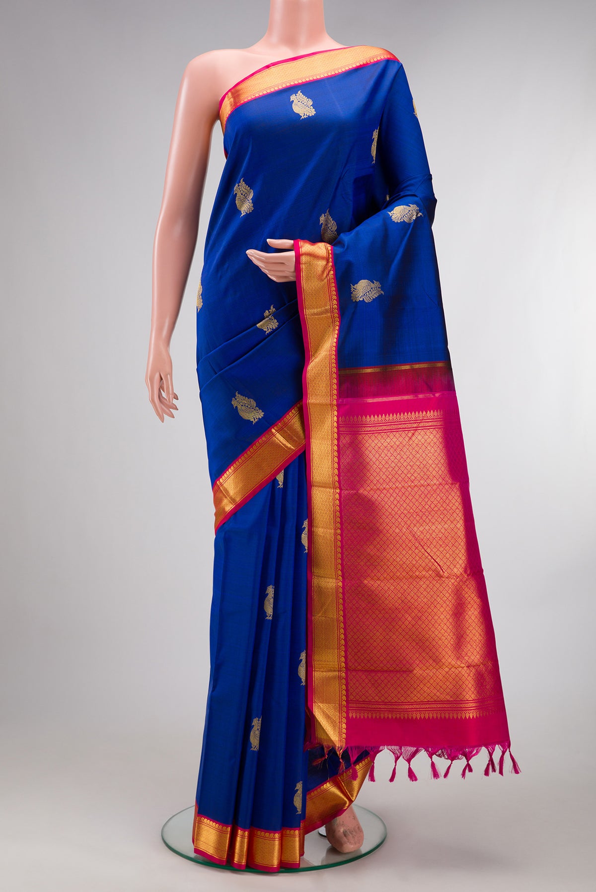 Pure Silk Royal Blue Kanjivaram Saree with Zari Butta on the body and Zari Border.  displayed on a mannequin