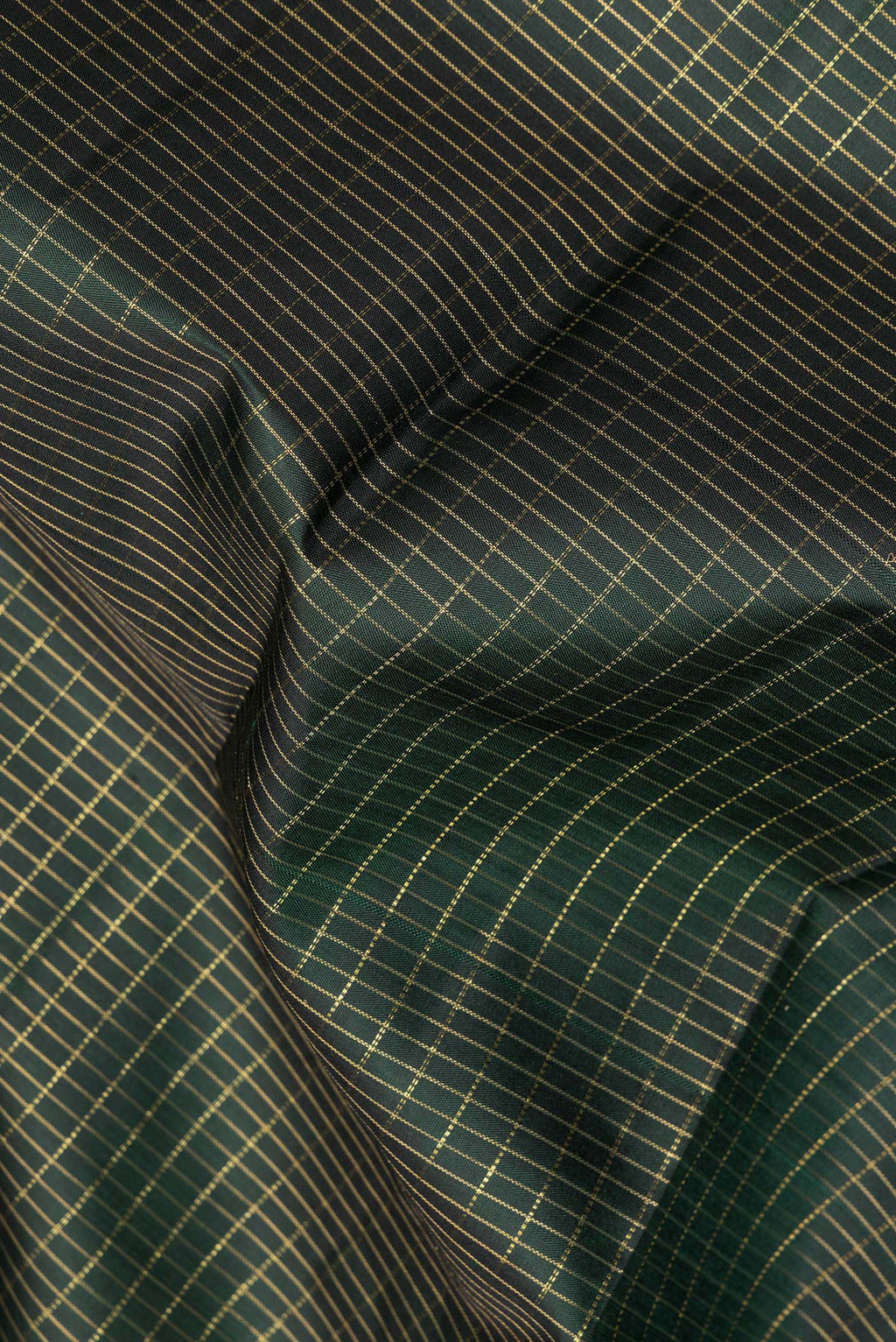 Close up of Pure Silk Bottle Green Dual Tone Kanchipuram Saree with Checked design on the body and Zari Border.  displaying folds