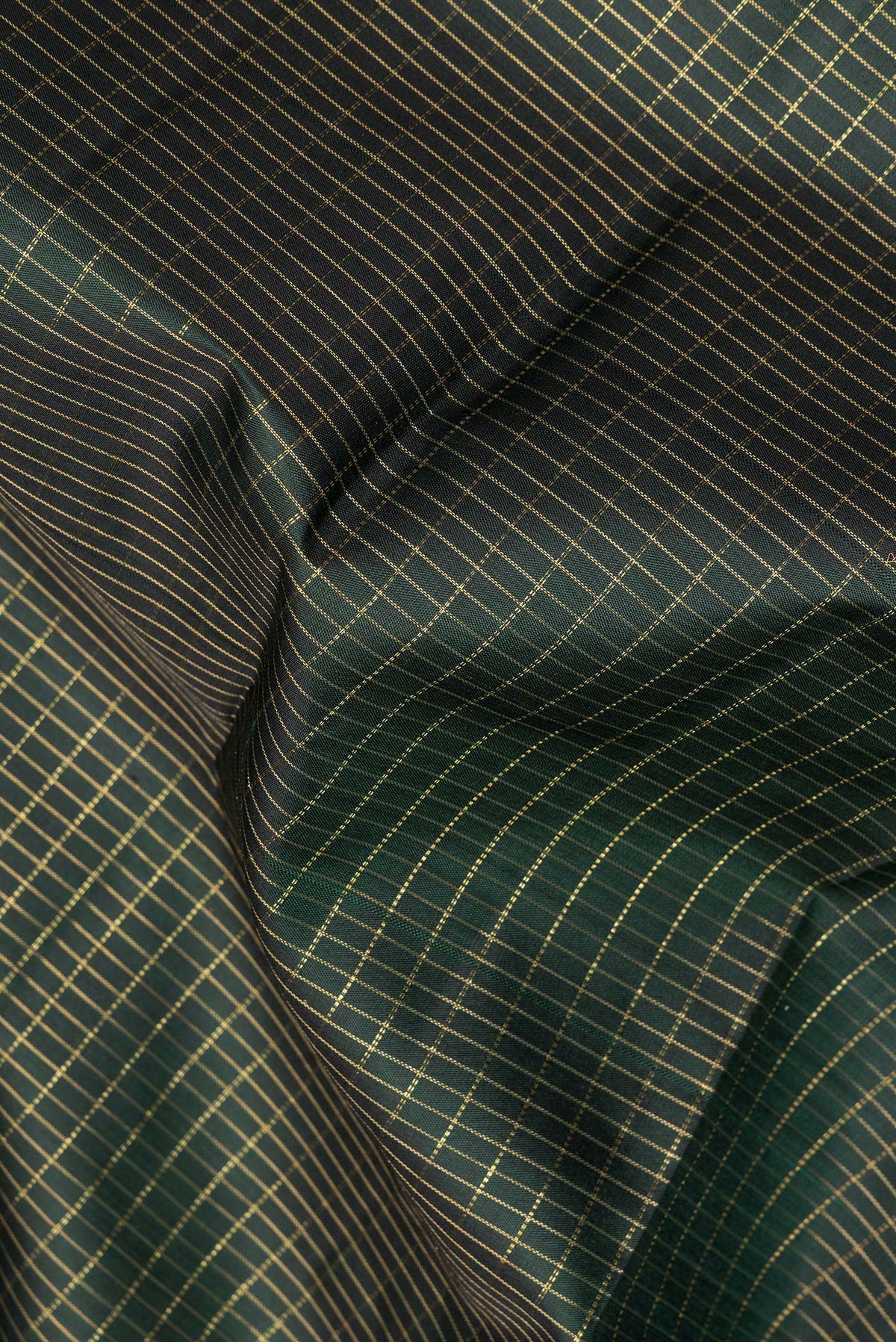 Close up of Pure Silk Bottle Green Dual Tone Kanchipuram Saree with Checked design on the body and Zari Border.  displaying folds