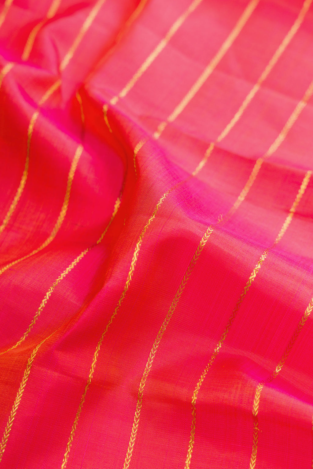Close up of Pure Silk Coral Dual Tone Kanjivaram Saree with Veldhari on the body and Ganga Jamuna Border.  displaying folds