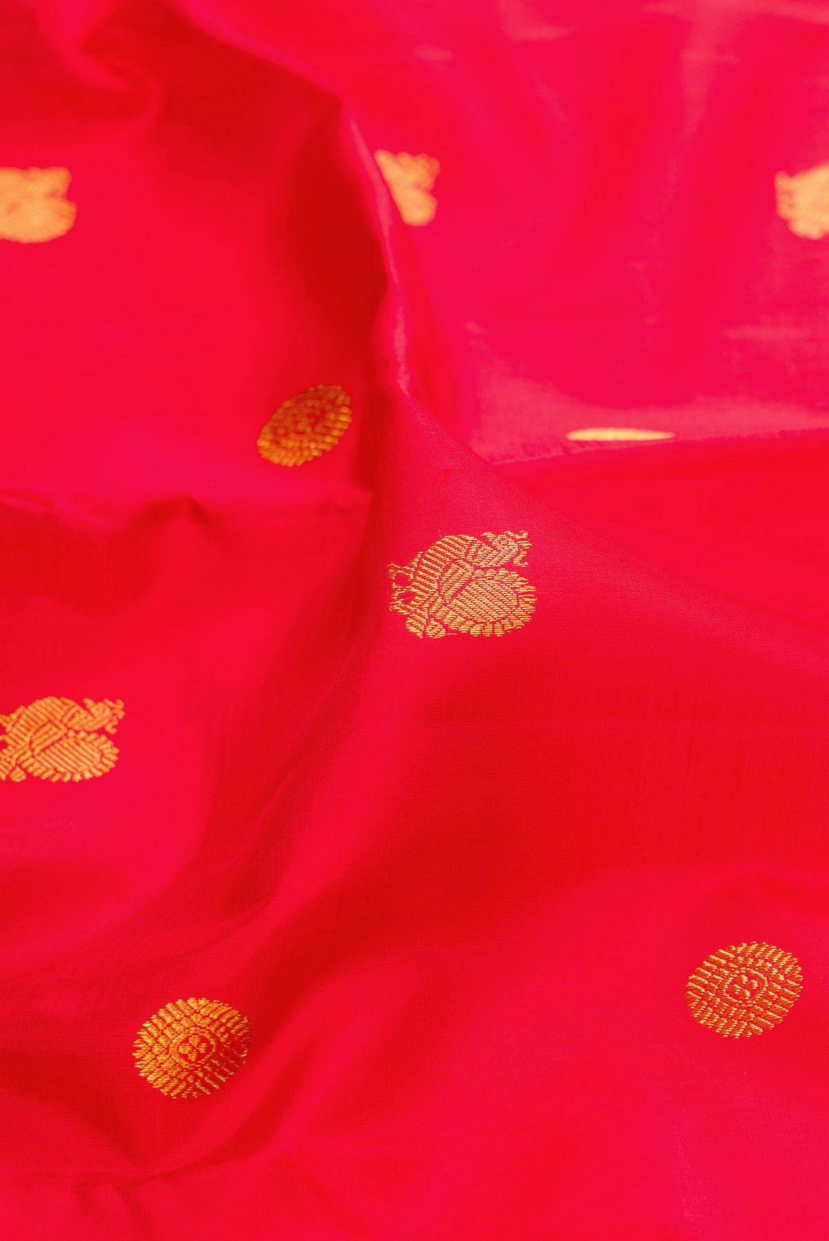 Close up of Pure Silk Red Kanjivaram Saree with Zari Butta on the body and Zari Border.  displaying folds