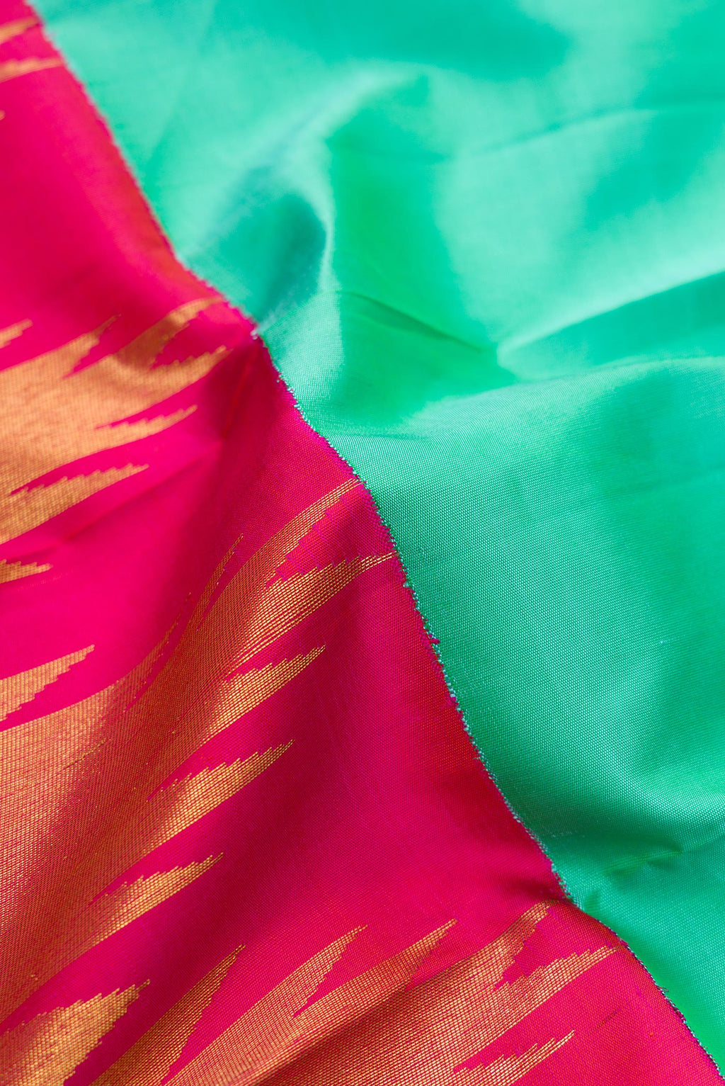 Close up of Pure Silk Pure Zari Sea Green Dual Tone Kanjivaram Saree with Half And Half on the body and Zari And Thread Border.  displaying folds