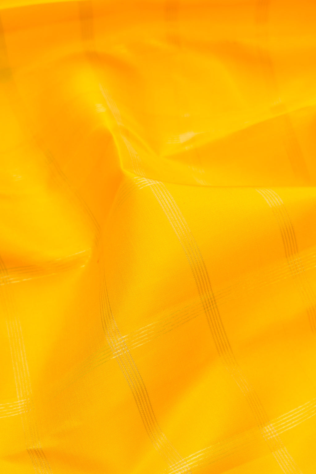 Close up of Pure Silk Pure Zari Yellow Kanjivaram Saree with Checked design on the body and Temple Border.  displaying folds