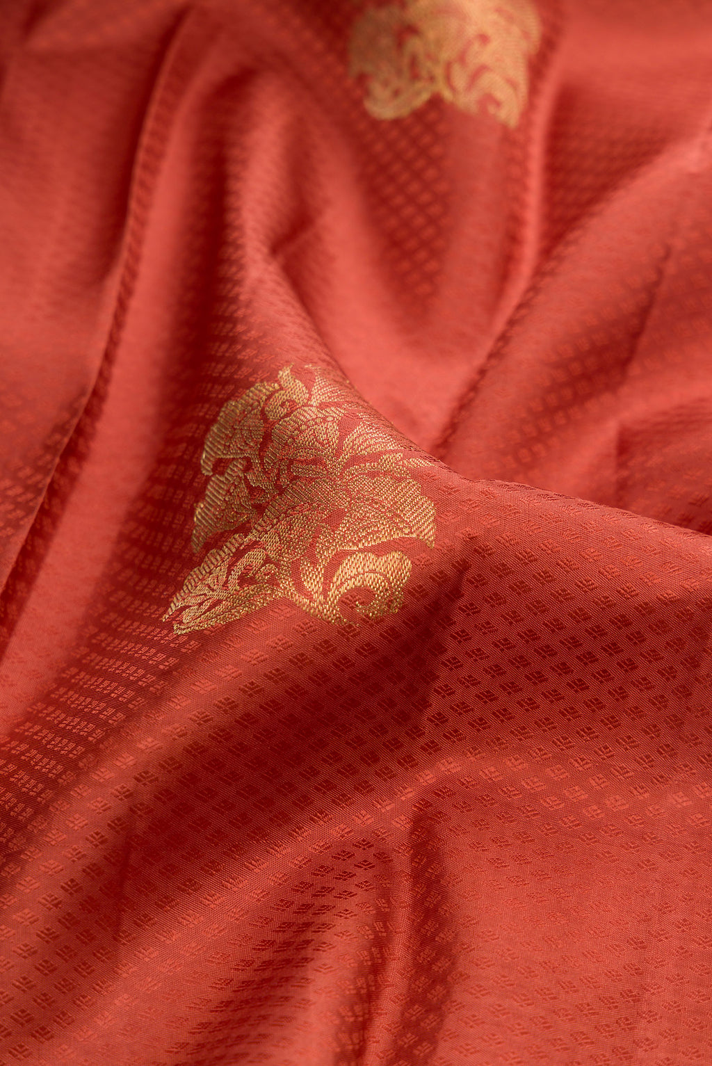 Close up of Pure Silk Rust Kanjivaram Saree with Jacquard With Zari Butta on the body and Zari Border.  displaying folds