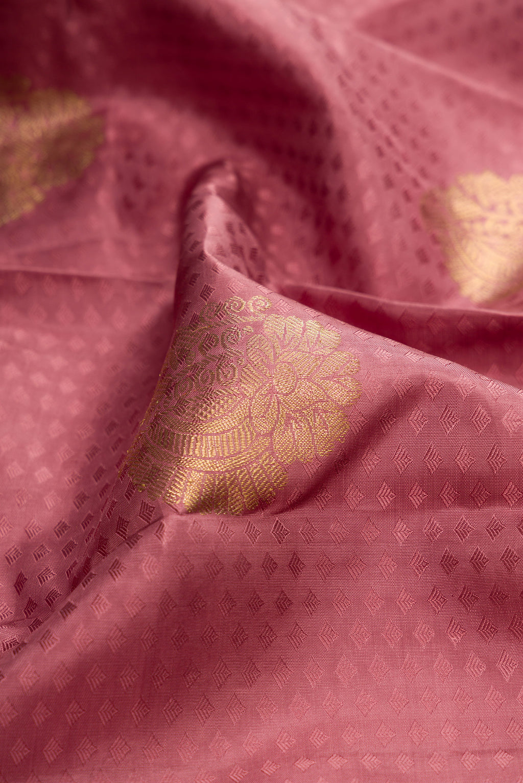 Close up of Pure Silk Peach Kanjivaram Saree with Jacquard With Zari Butta on the body and Zari Border.  displaying folds