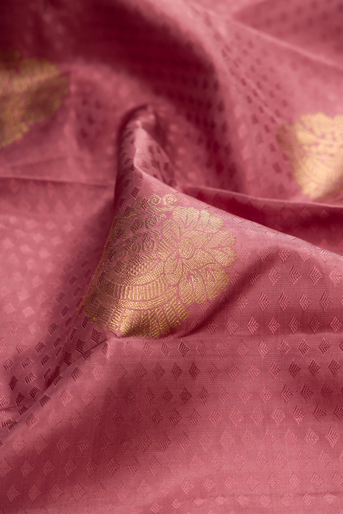 Close up of Pure Silk Peach Kanjivaram Saree with Jacquard With Zari Butta on the body and Zari Border.  displaying folds