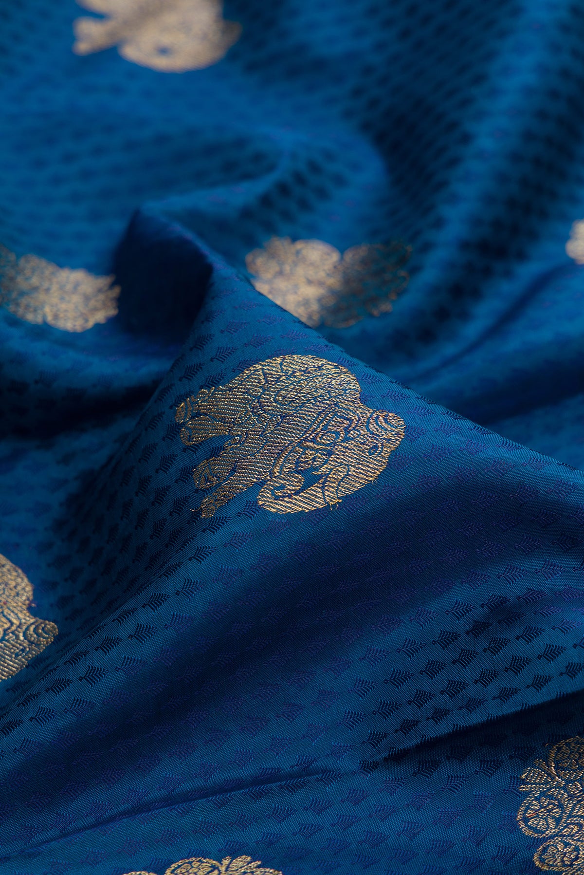 Close up of Pure Silk Peacock Blue Kanjivaram Saree with Jacquard With Zari Butta on the body and Zari Border.  displaying folds
