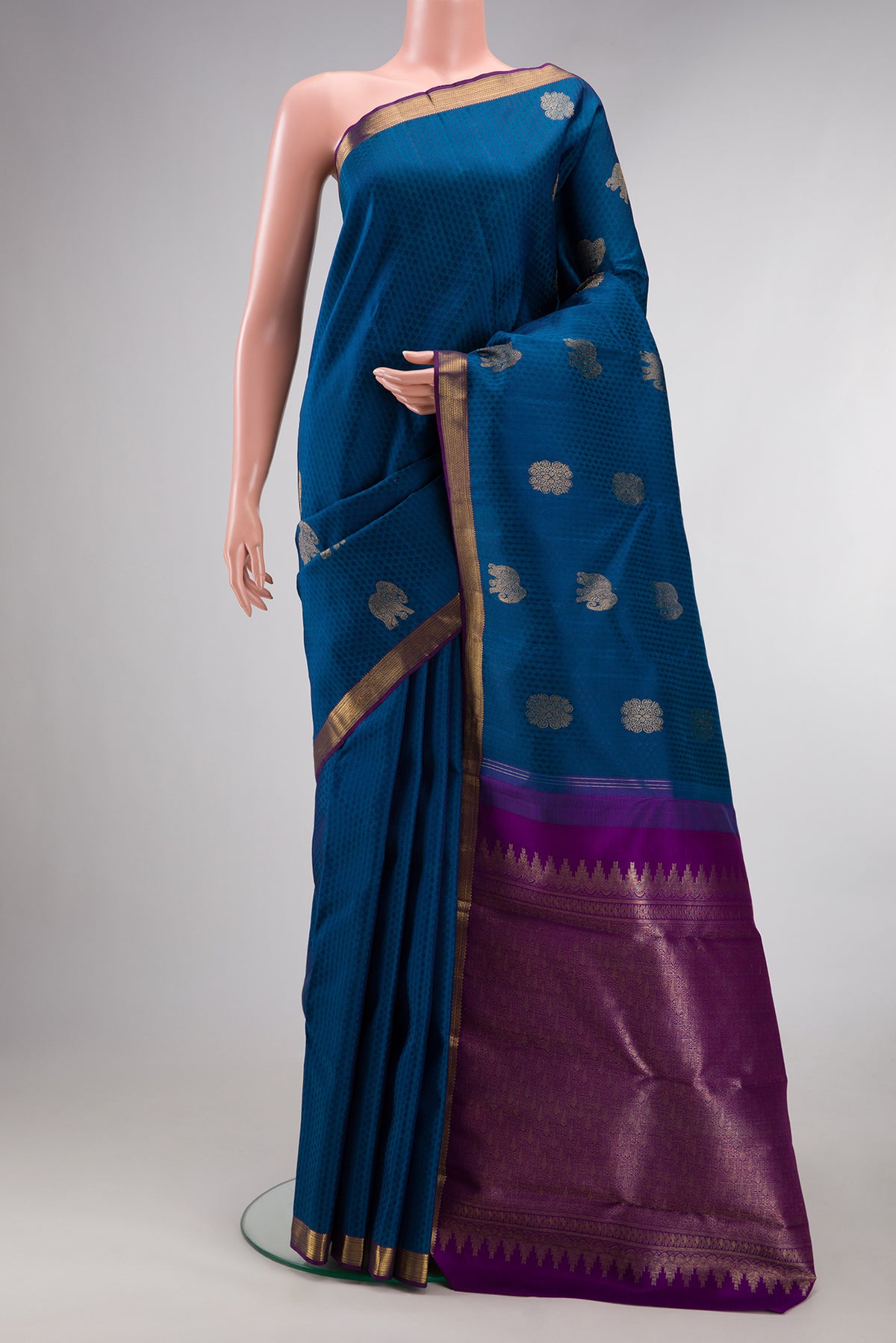 Pure Silk Peacock Blue Kanjivaram Saree with Jacquard With Zari Butta on the body and Zari Border.  displayed on a mannequin
