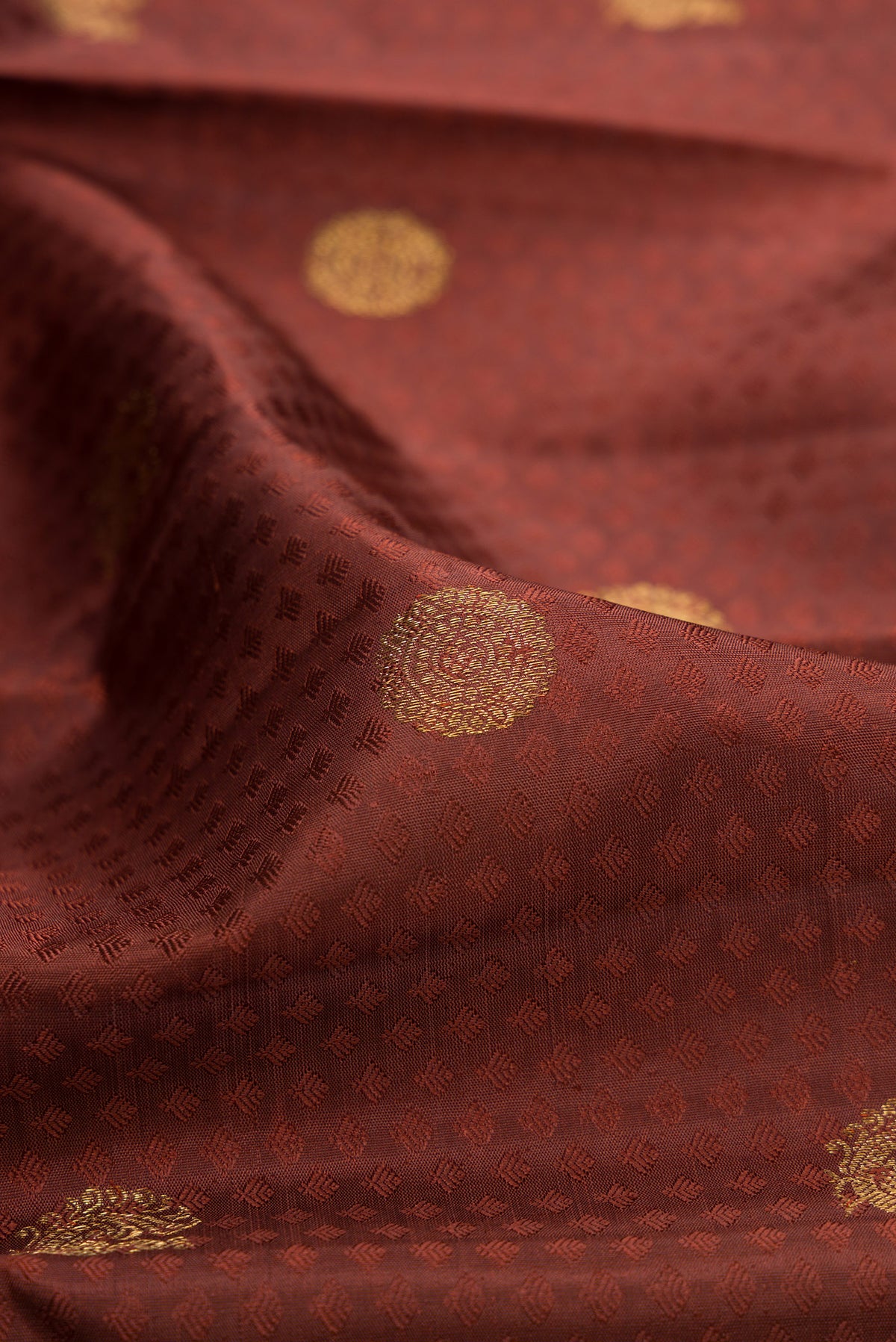 Close up of Pure Silk Brown Kanjivaram Saree with Jacquard With Zari Butta on the body and Zari Border.  displaying folds