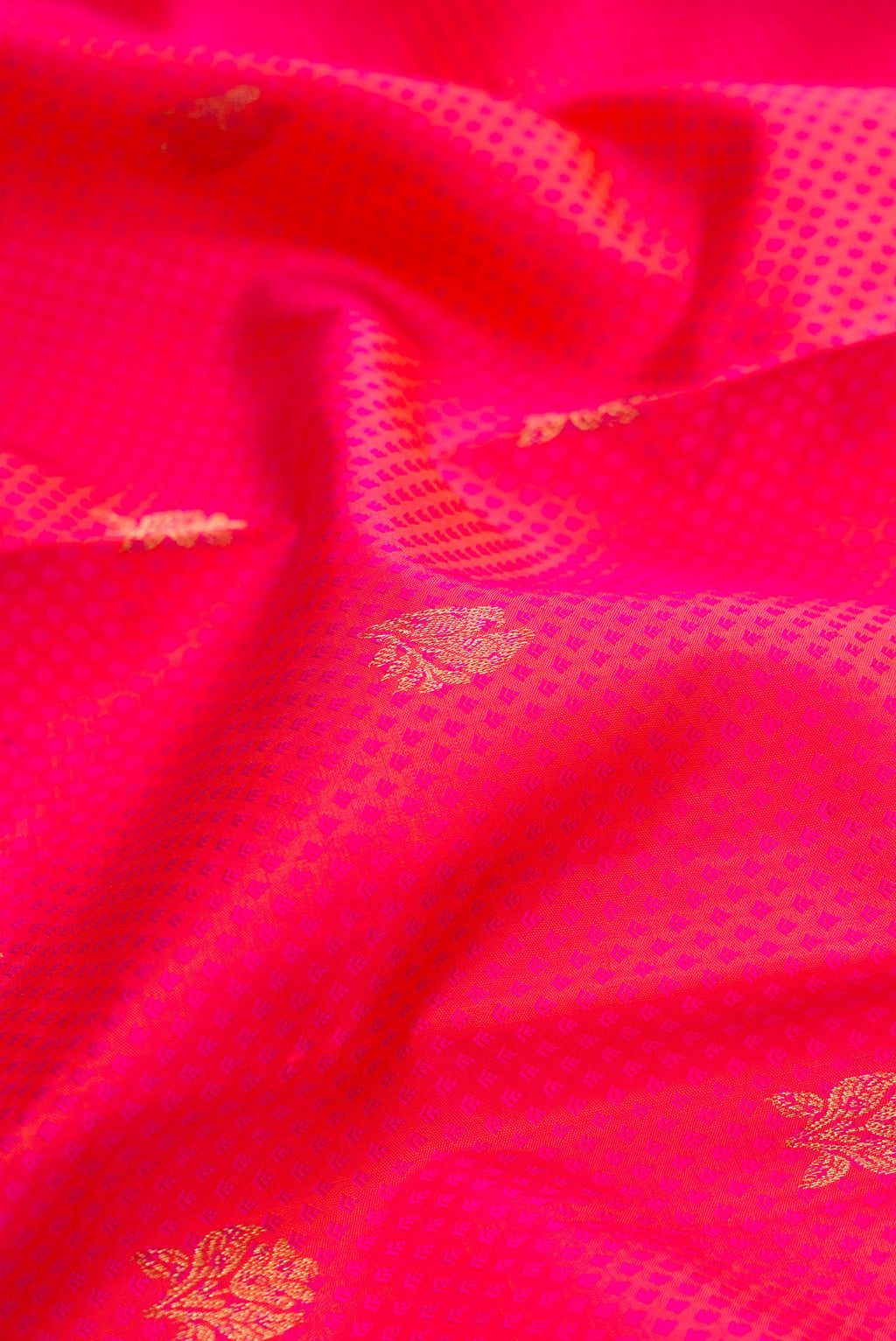 Close up of Pure Silk Coral Kanchipuram Saree with Jacquard With Zari Butta on the body and Zari Border.  displaying folds