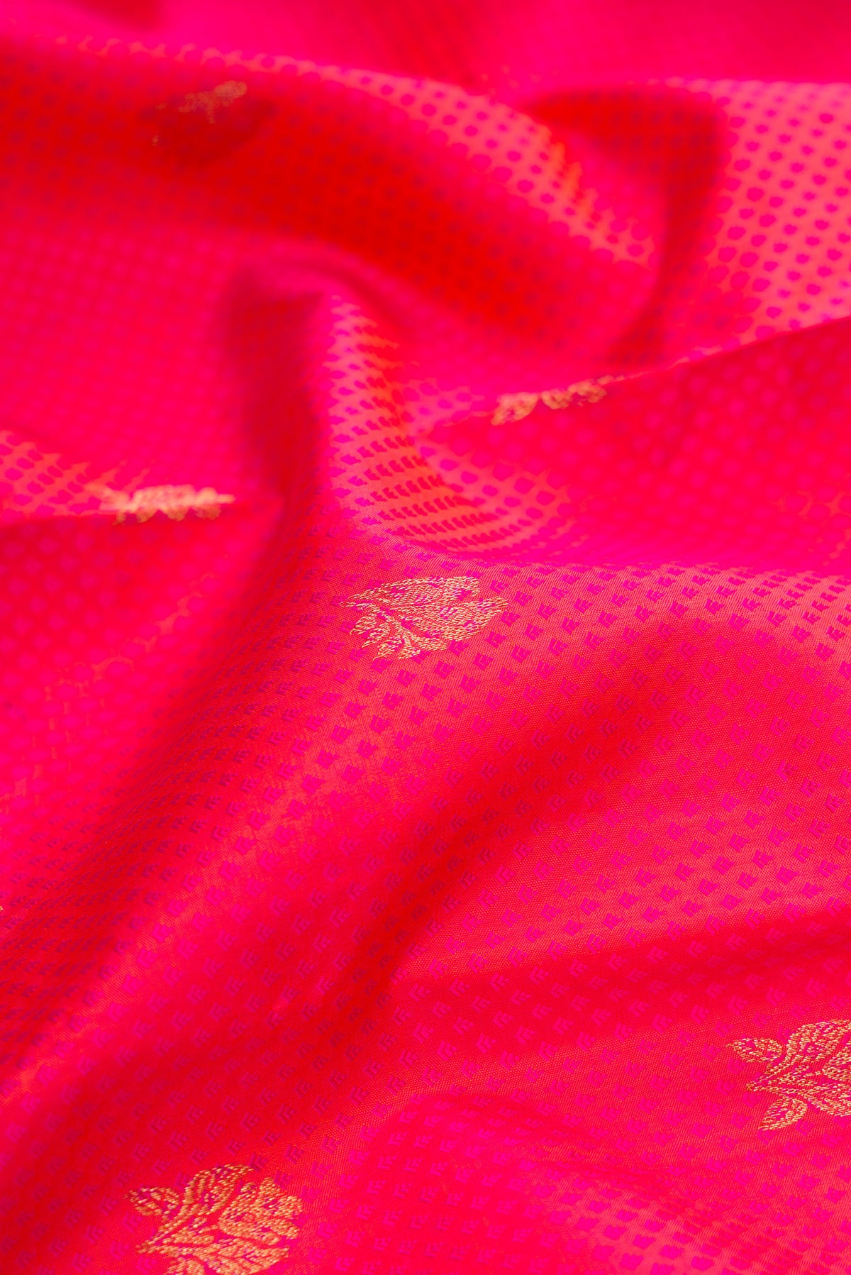Close up of Pure Silk Coral Kanchipuram Saree with Jacquard With Zari Butta on the body and Zari Border.  displaying folds
