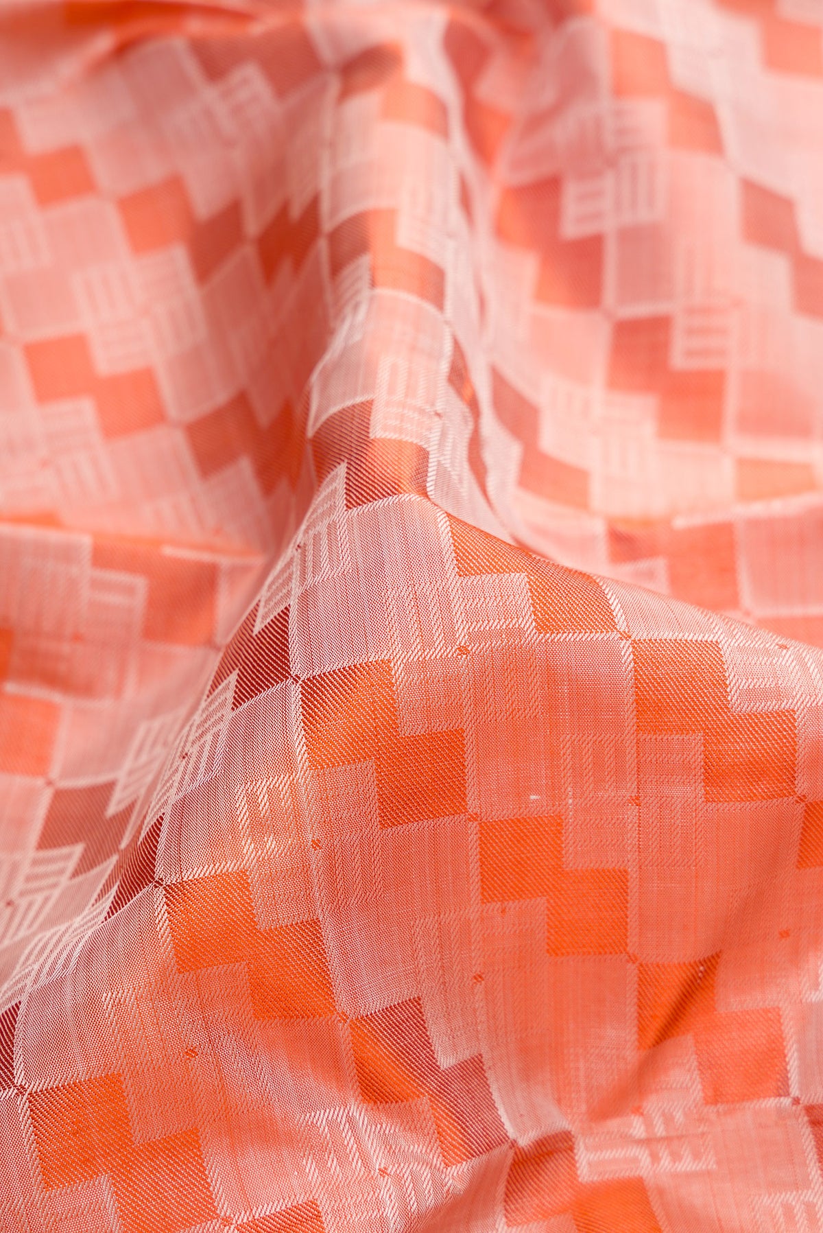 Close up of Pure Silk Pure Zari Orange Kanchipuram Saree with Jacquard design on the body and Zari Border.  displaying folds