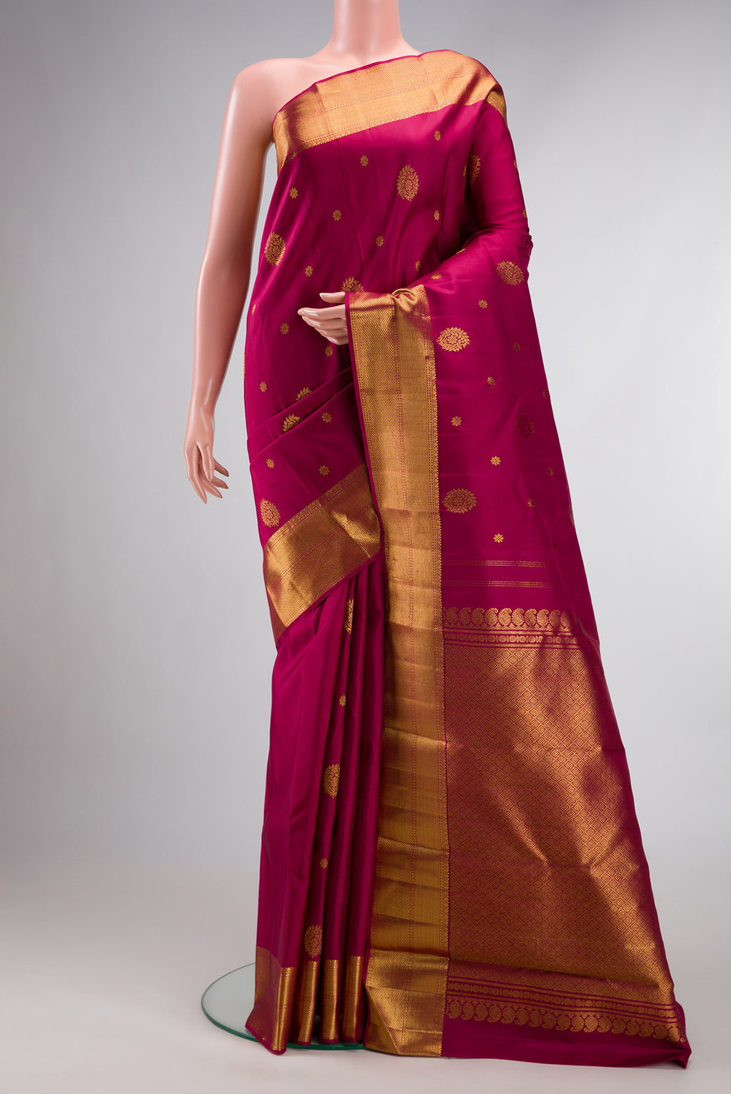 Pure Silk Maroon Kanjivaram Saree with Zari Butta on the body and Zari Border.  displayed on a mannequin